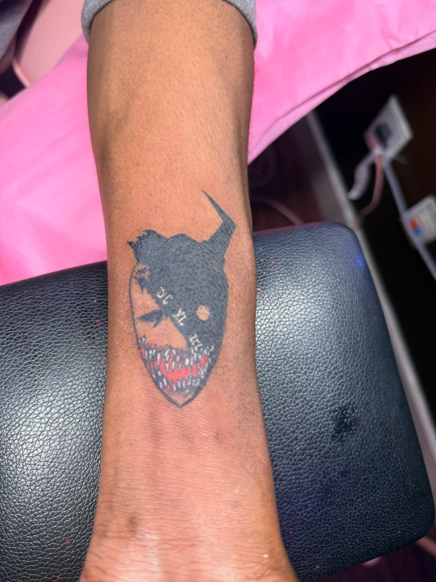 Mask with horns black and grey tattoo on the forearm by Tattoos by Santos