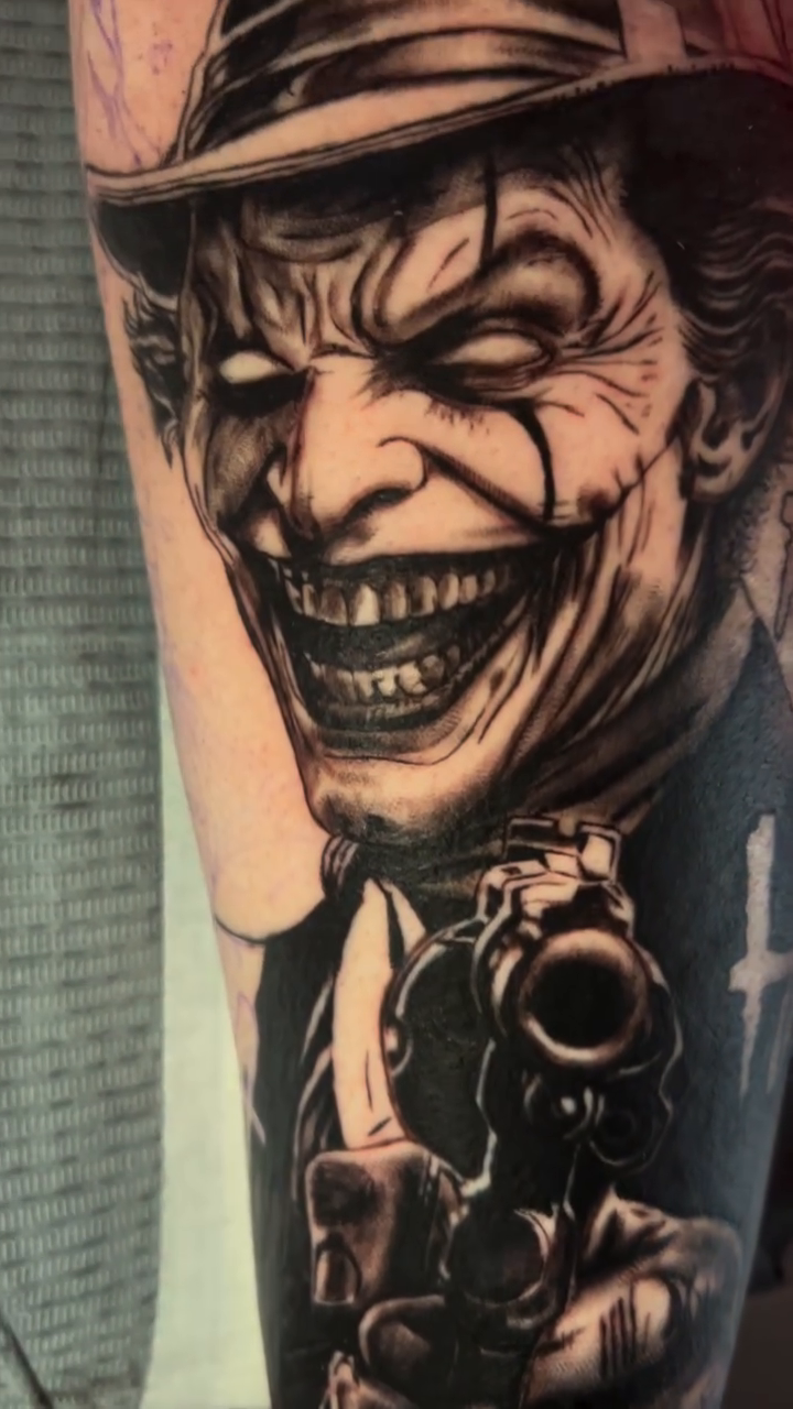 The Joker with a gun realism tattoo by Gage Cottrell