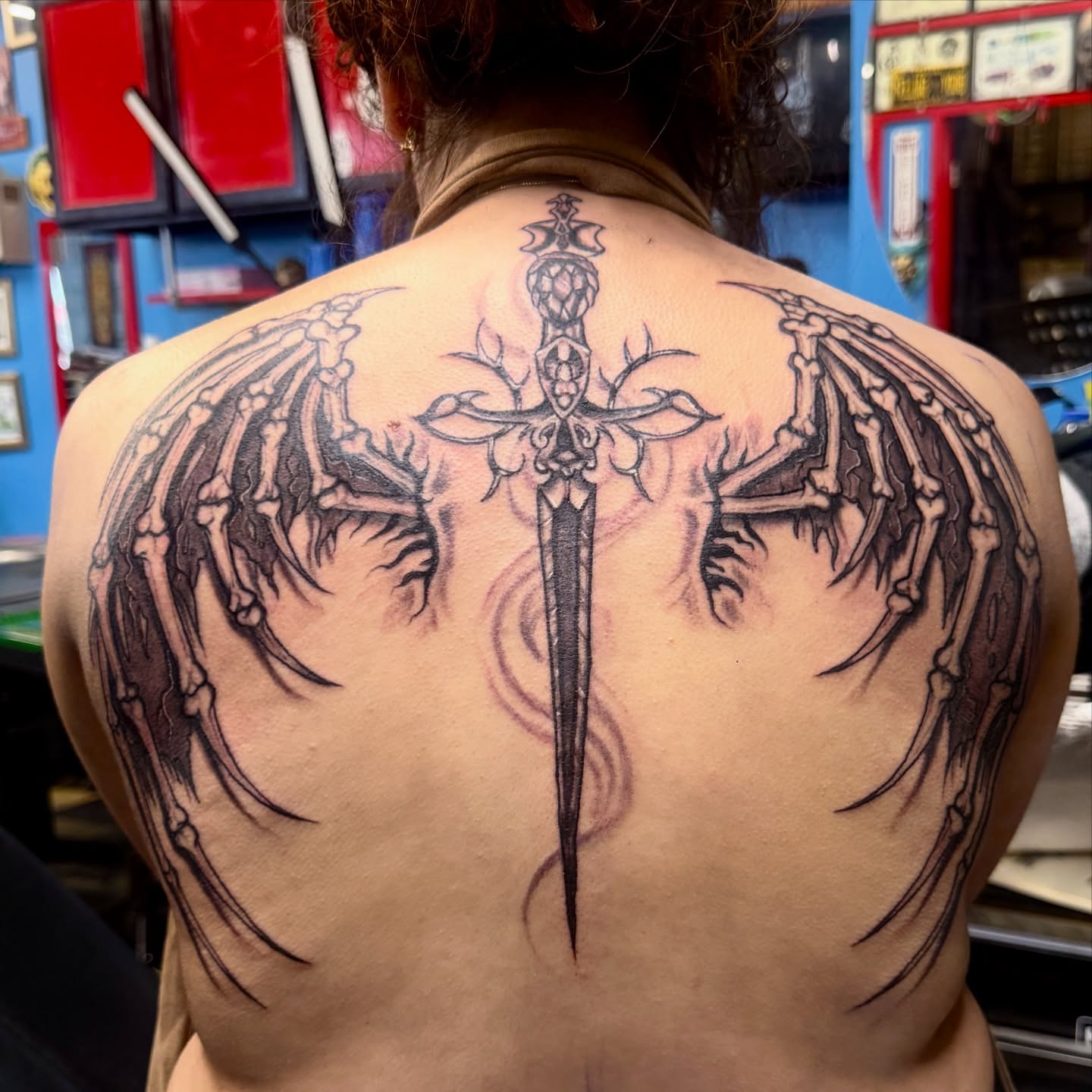 Sword with wings realism tattoo on the back by Gary Chase