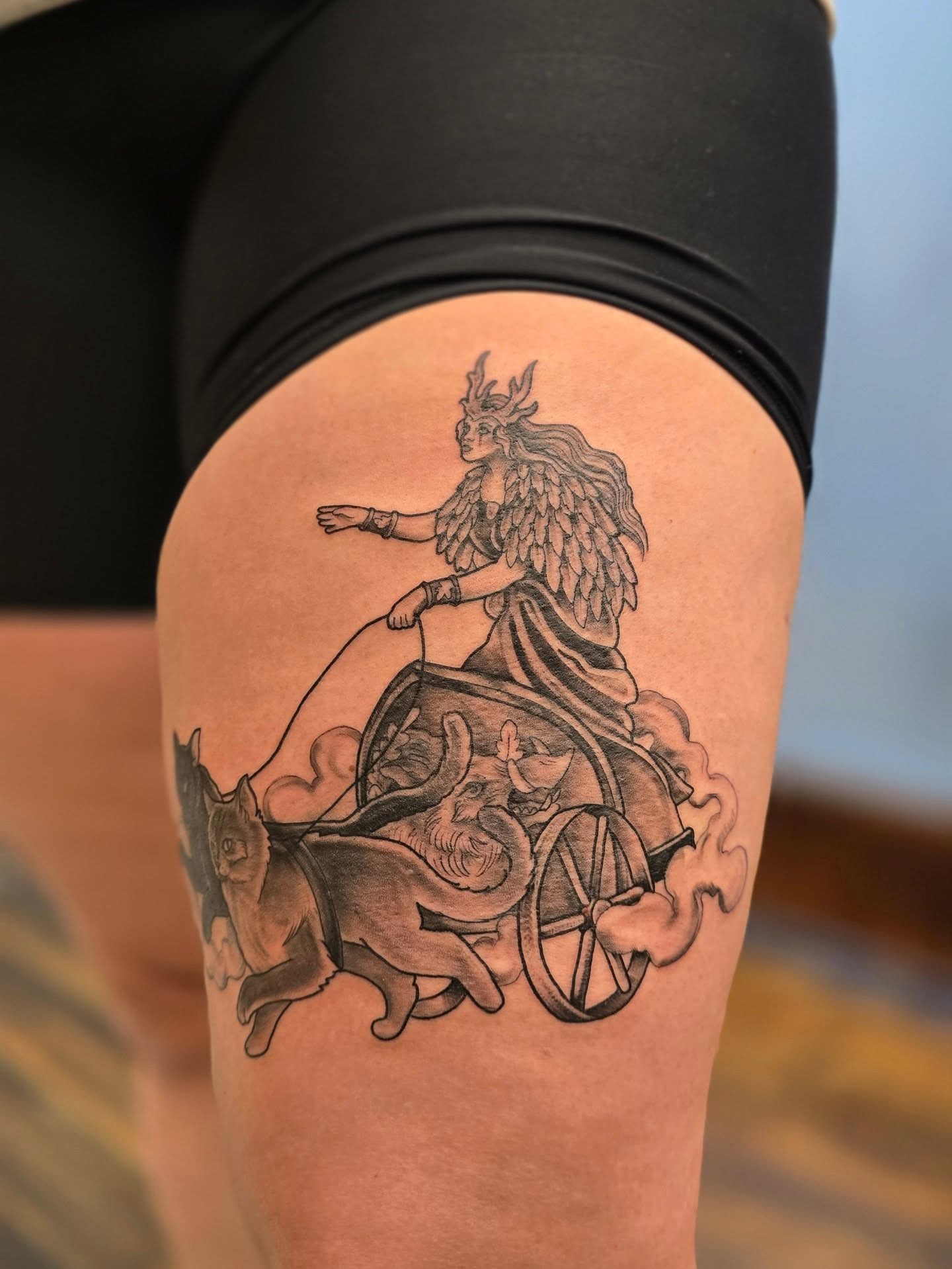 Mythical figure driving chariot black and grey tattoo on the thigh by 𝙼𝚒𝚔𝚎 𝙴𝚌𝚔𝚋𝚘𝚛𝚐