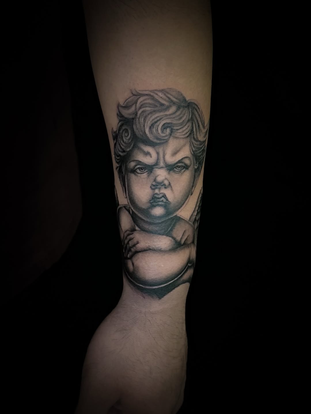 Grumpy cherub realism tattoo on the forearm by Juan c munoz jr, Chicago, Illinois
