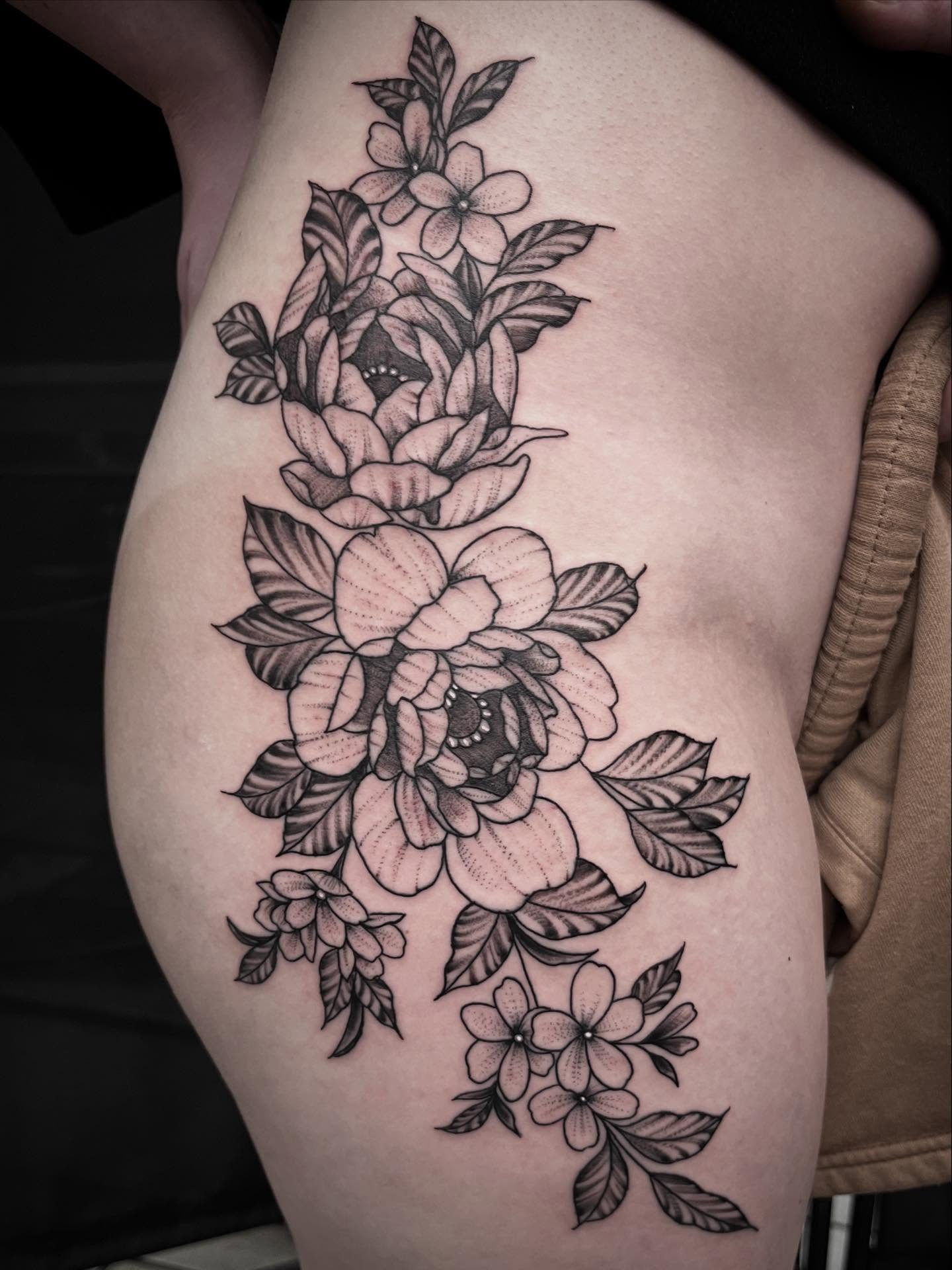 Floral bouquet black and grey tattoo on the thigh by Sean Gallagher