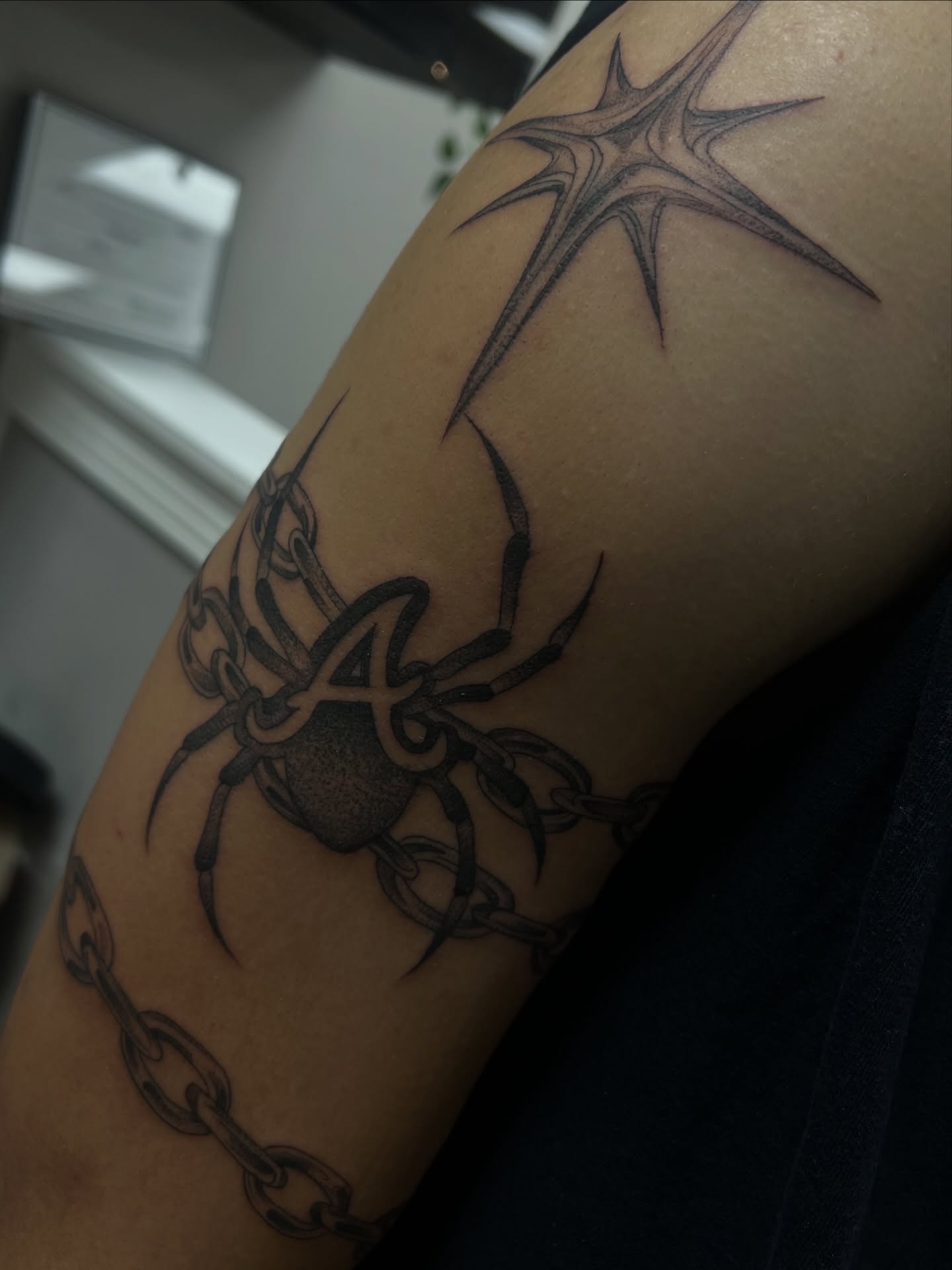 Spider and chain black and grey tattoo on the forearm by ashlyn rene
