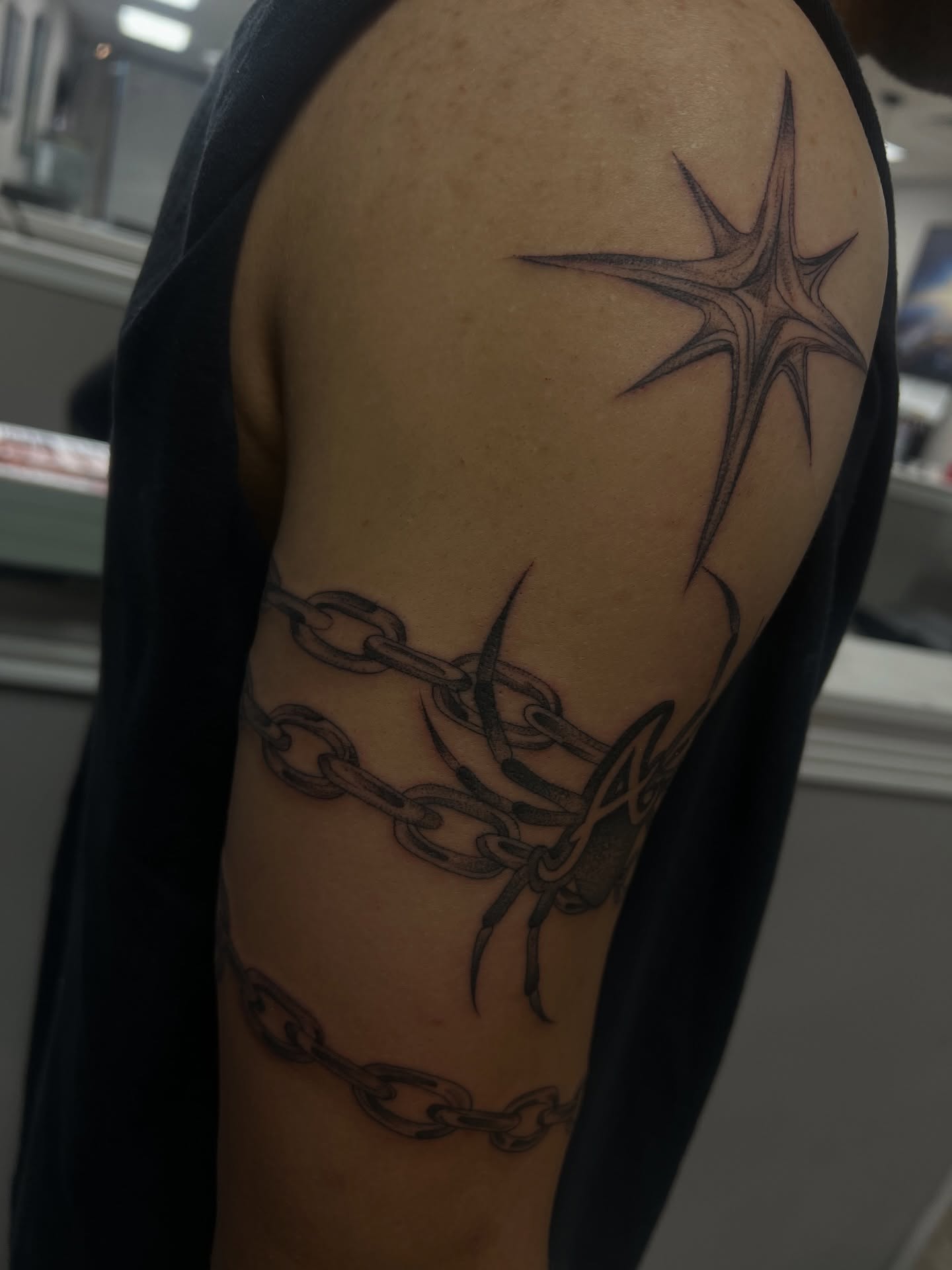 Chains and star black and grey tattoo on the upper arm by ashlyn rene