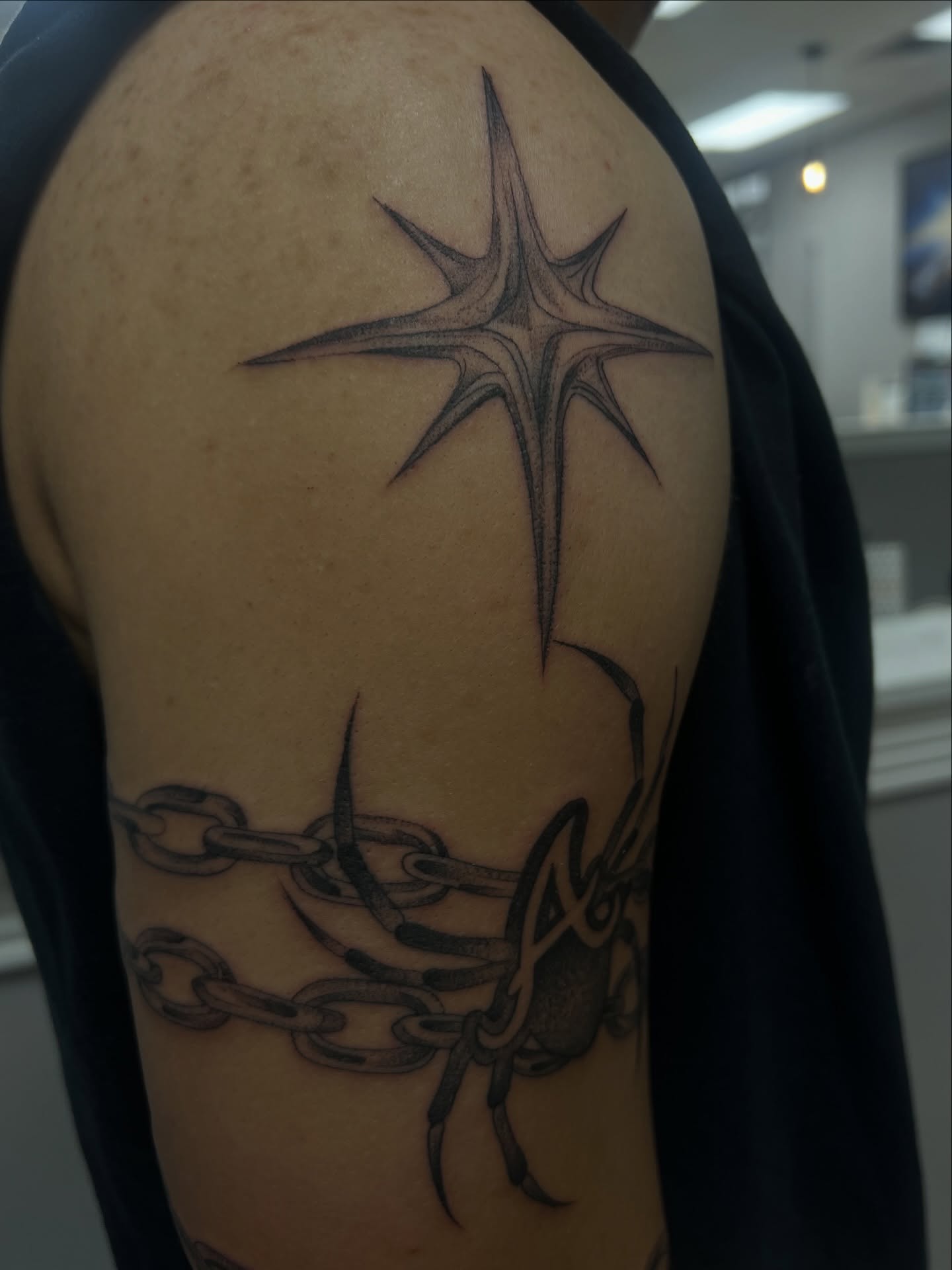 Star and chains black and grey tattoo on the shoulder by ashlyn rene