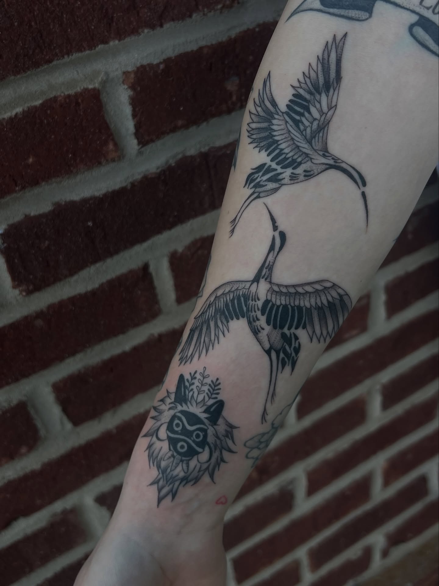 Cranes and mask black and grey tattoo on the forearm by ashlyn rene