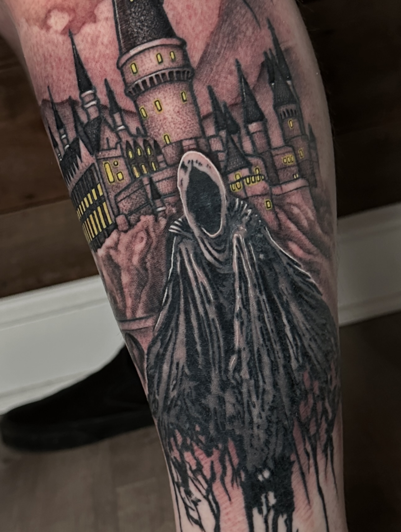 Hogwarts castle and Grim Reaper dark realism tattoo on the forearm by Joe Friedman