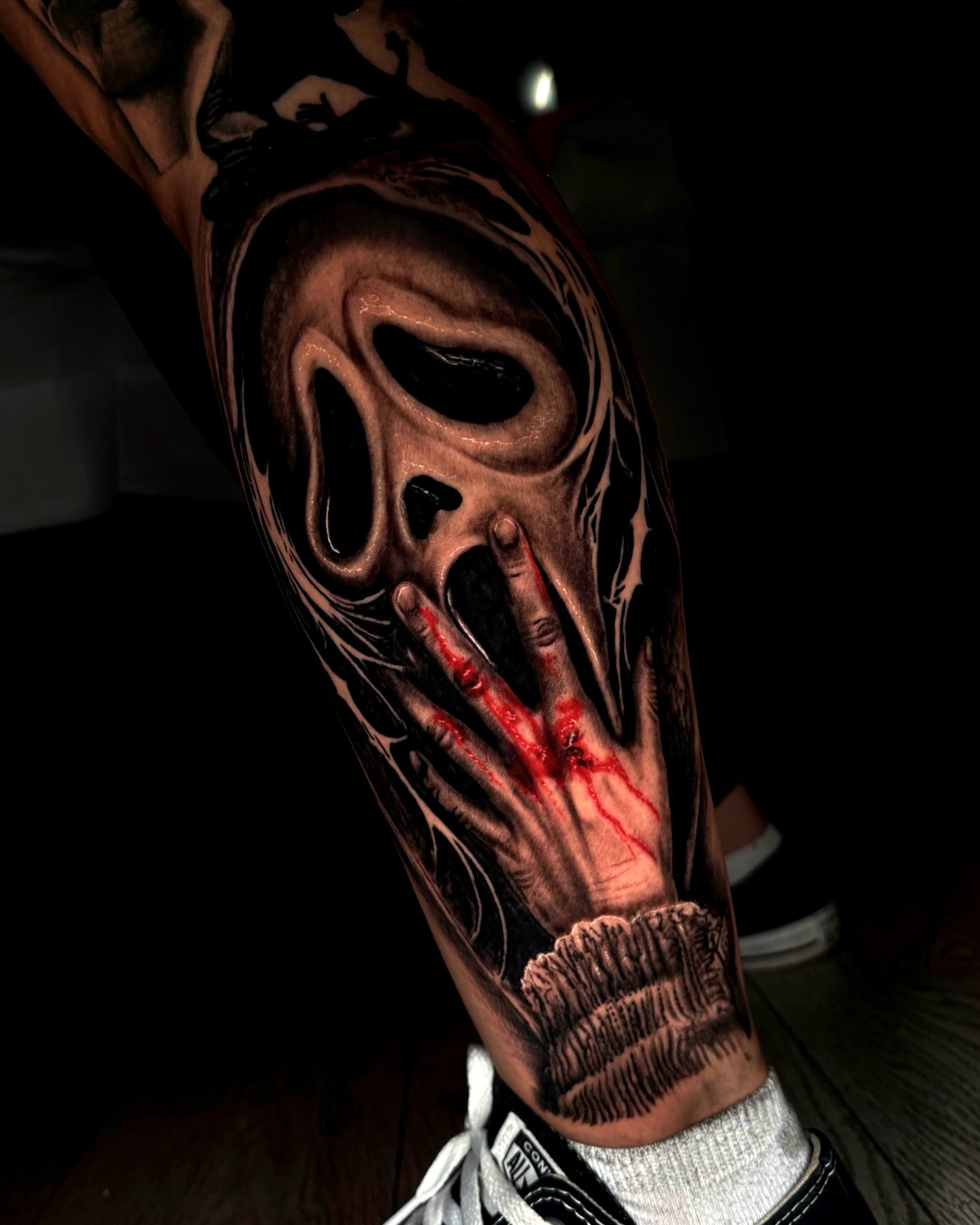 Mask with hand dark realism tattoo on the forearm by Trev