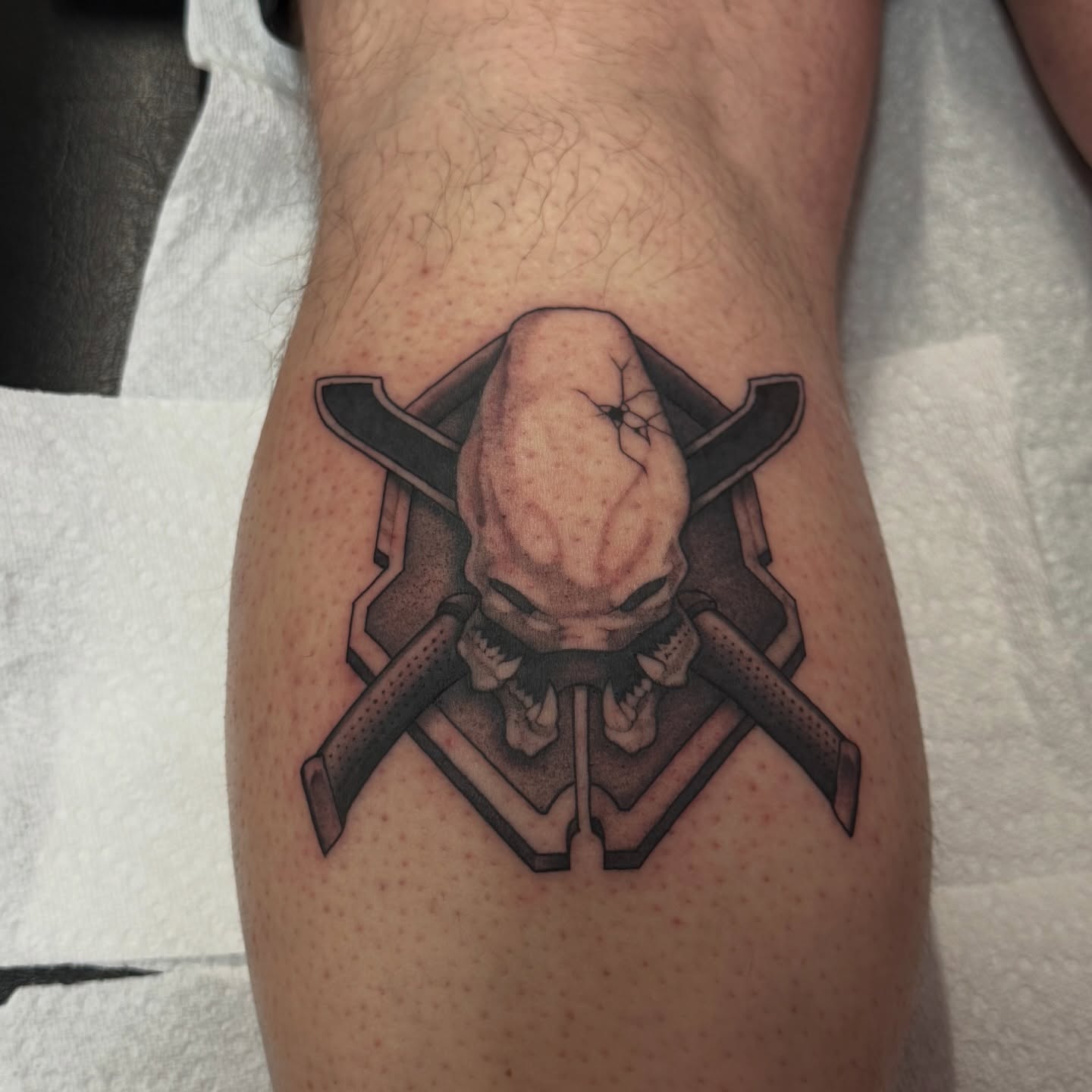 Alien head black and grey tattoo on the thigh by Casket