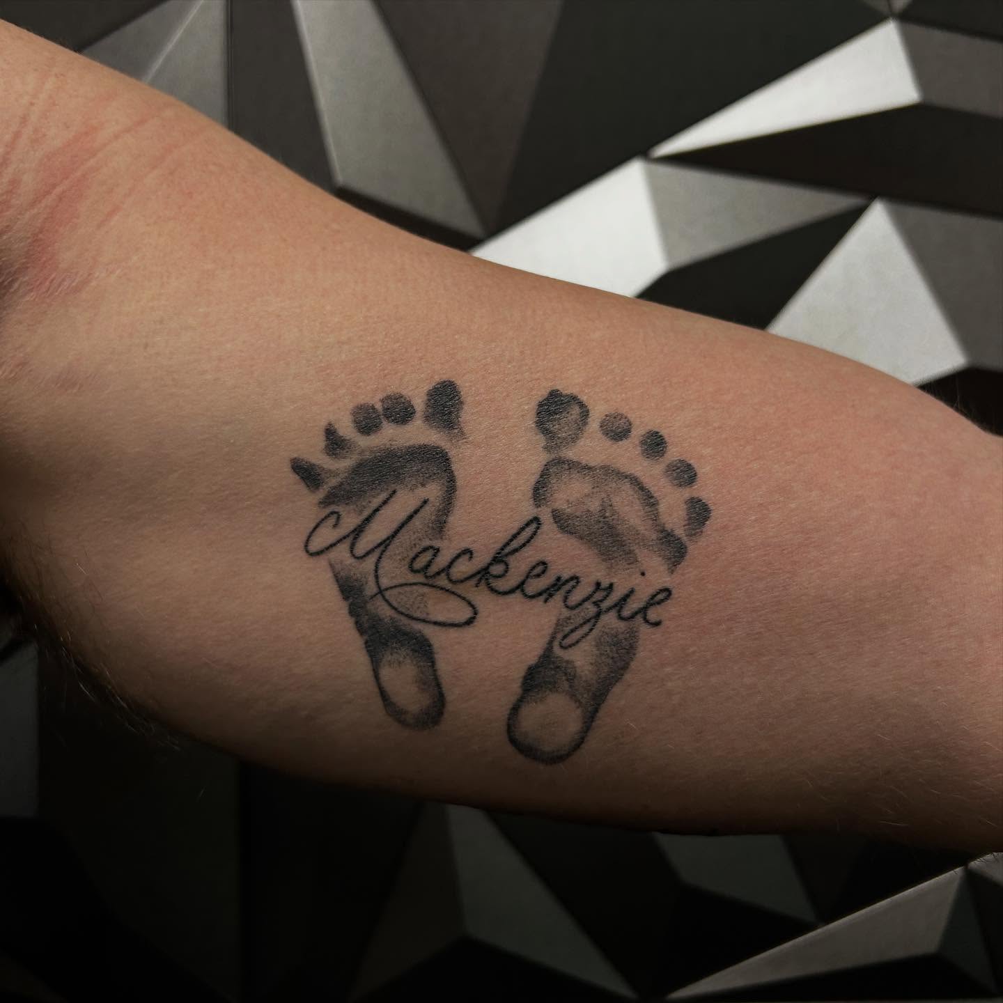 Baby footprints with name dotwork tattoo on the forearm by Leah Hammes