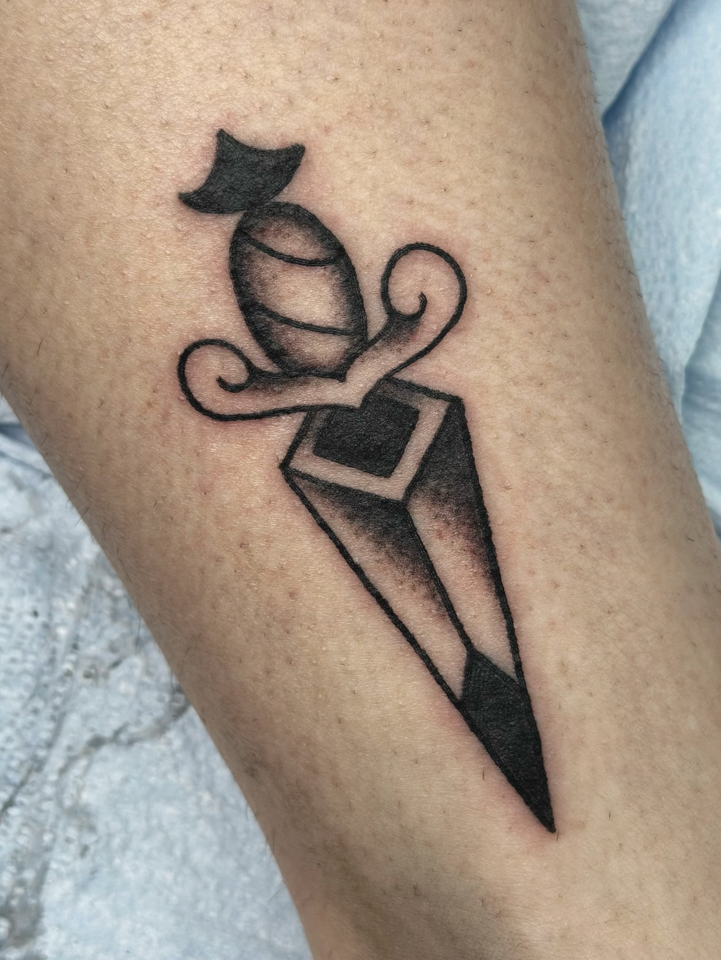 Knife and bomb black and grey tattoo on the forearm by Lucy Jay