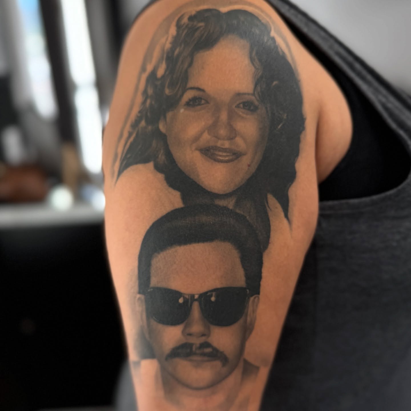 Portrait realism tattoo on the upper arm by tombstone