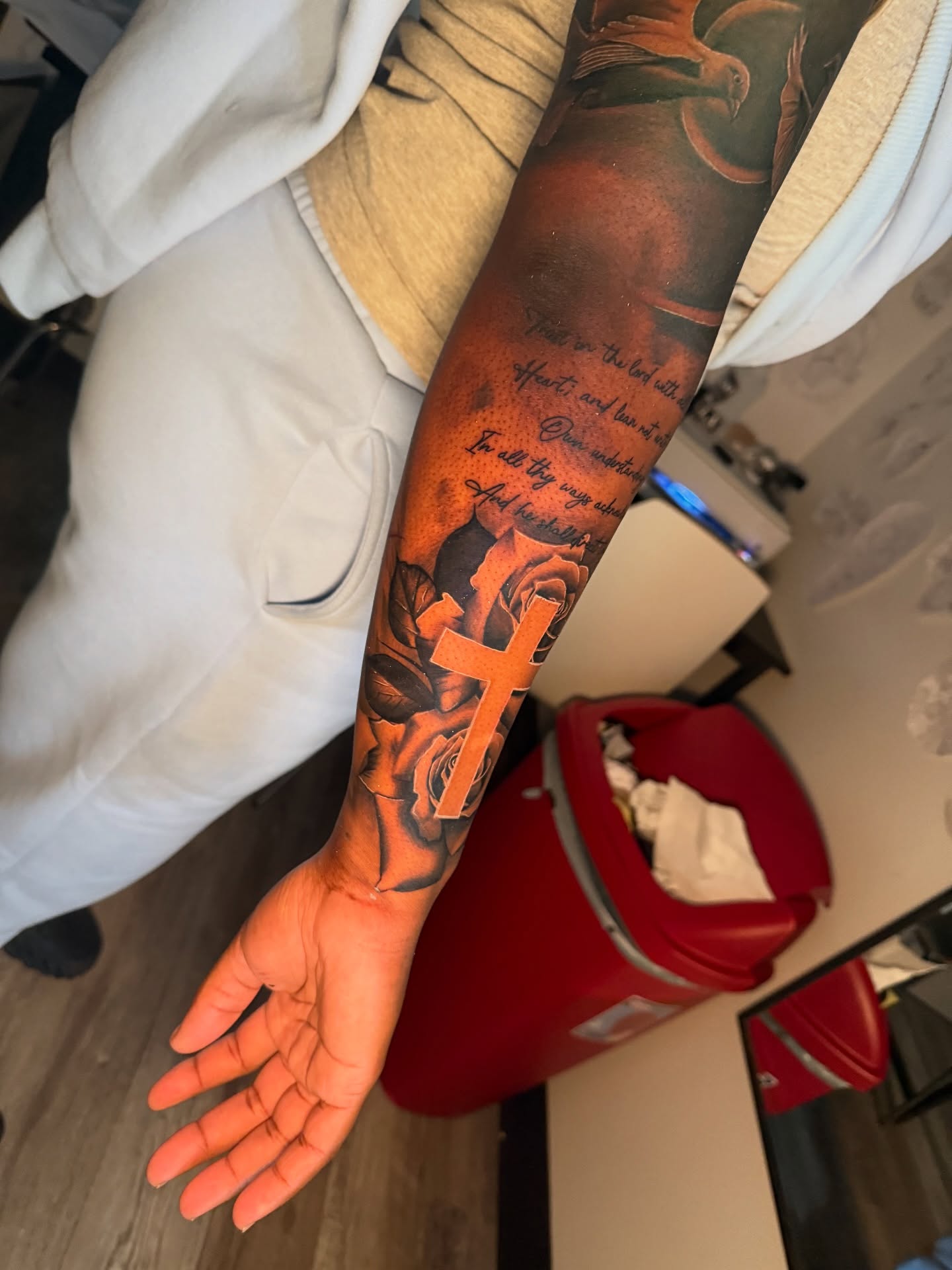 Cross and roses realism tattoo on the forearm by Atlanta Tattoo Artist