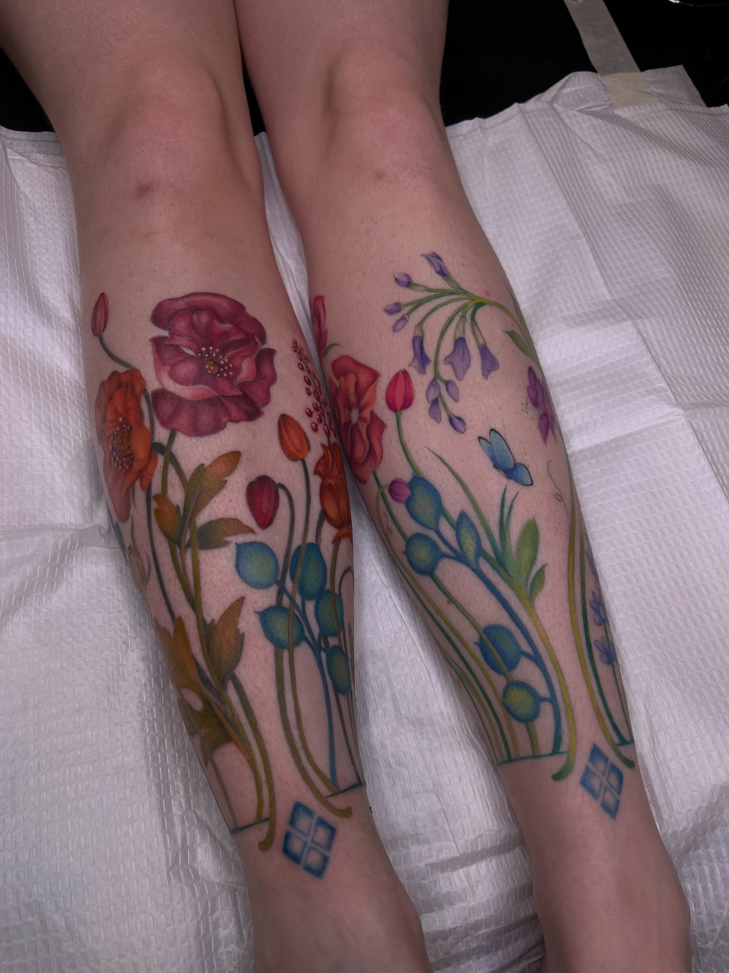 Floral bouquet watercolor tattoo on the calf by Kyla Jae