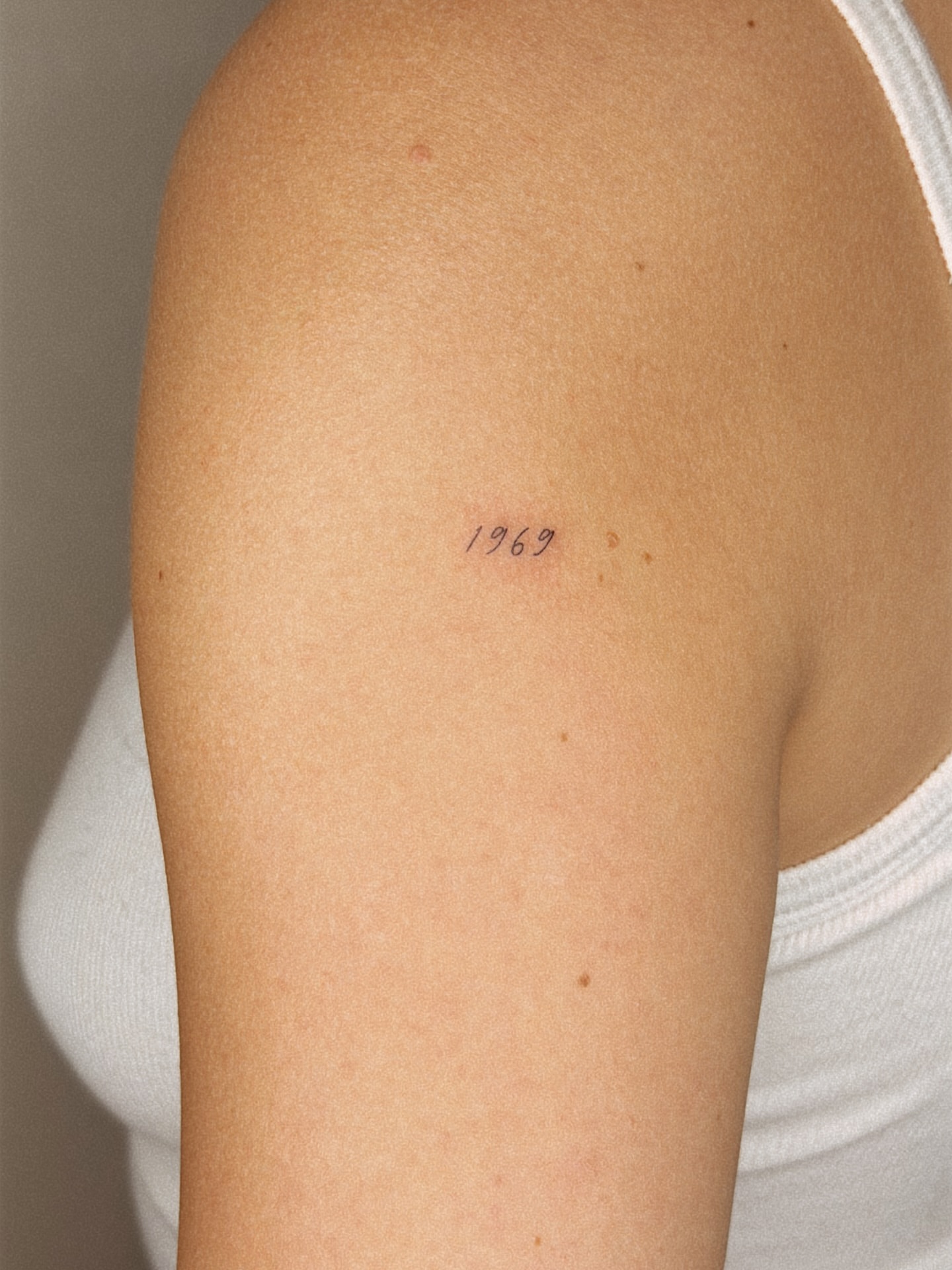 Numbers lettering script tattoo on the shoulder by Yuli Noama