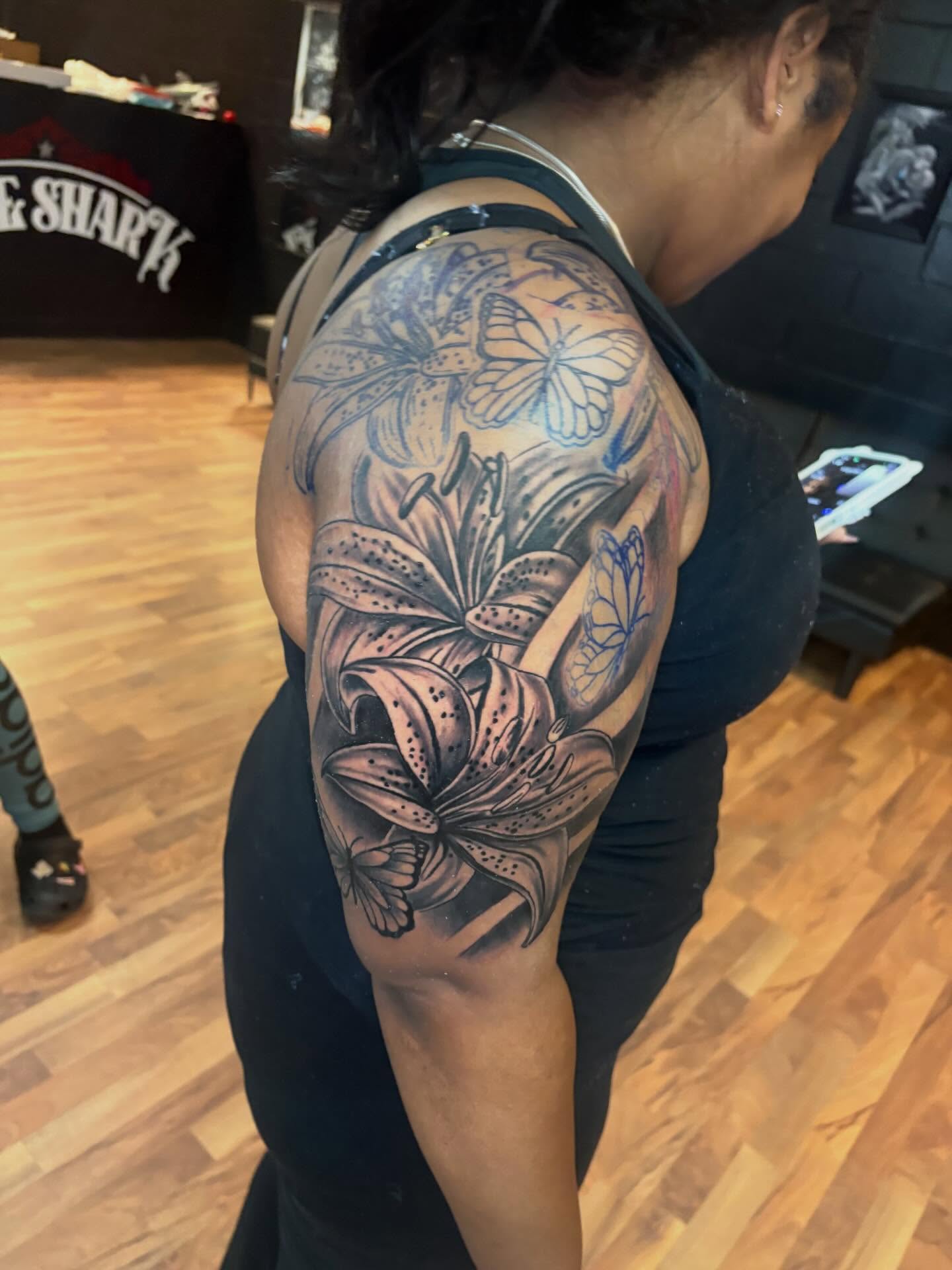 Lilies and butterflies black and grey tattoo on the shoulder by 𓂀 𝕊ℍ𝔼𝕃𝕃𝕐 𓂀