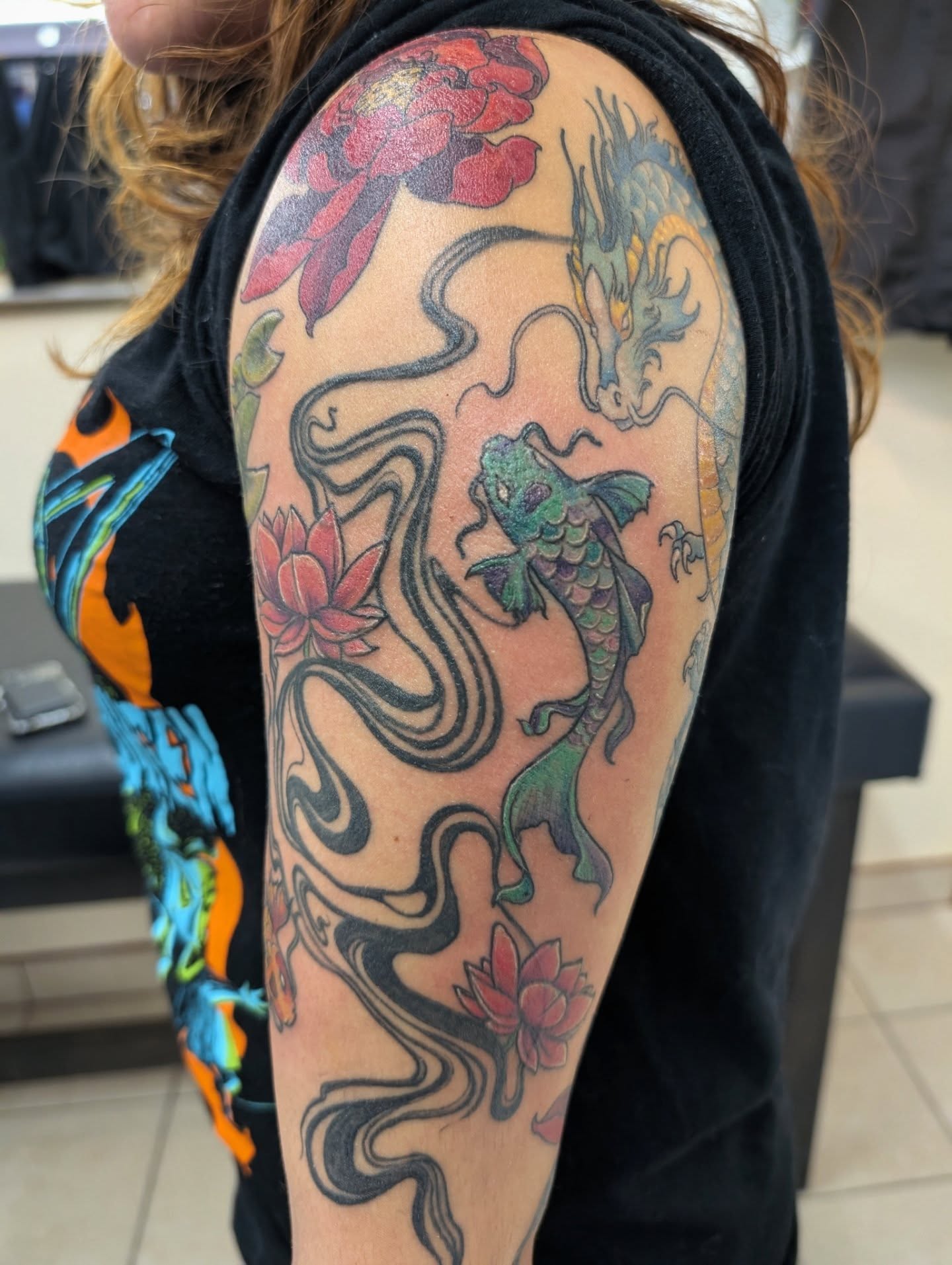 Koi fish and dragon japanese irezumi tattoo on the upper arm by Katherine