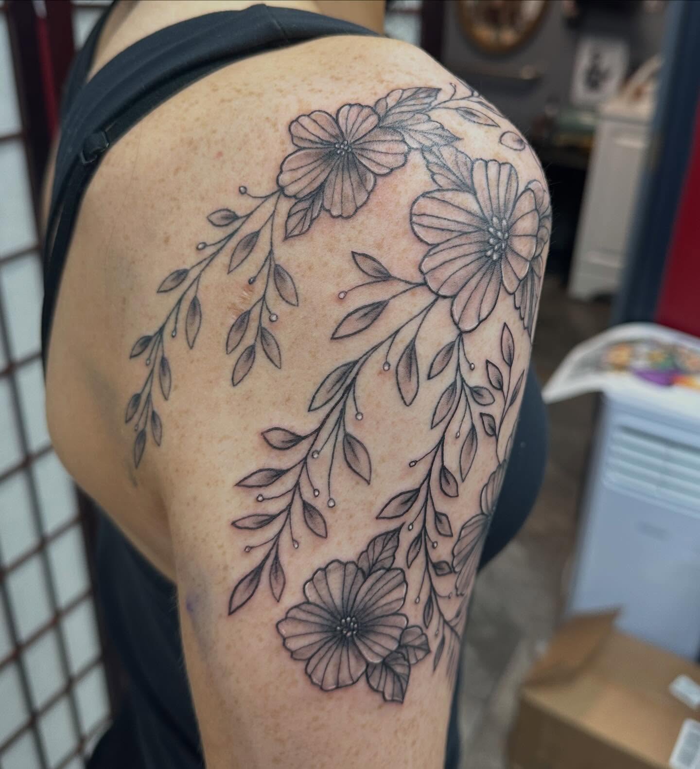 Floral arrangement black and grey tattoo on the shoulder by Olivia Norbert