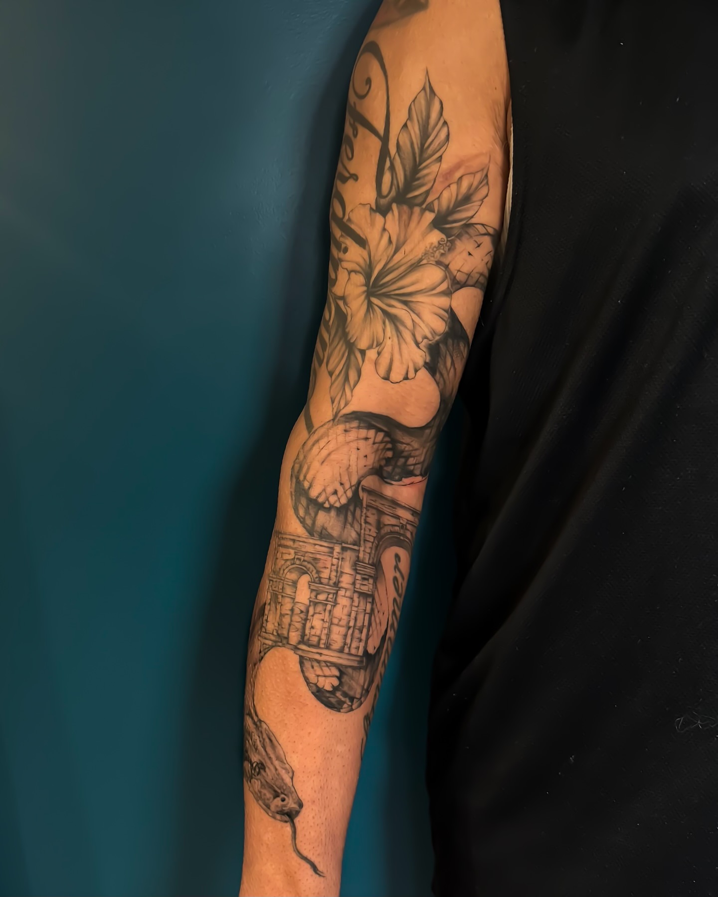 Snake and flowers black and grey tattoo on the forearm by Amelia