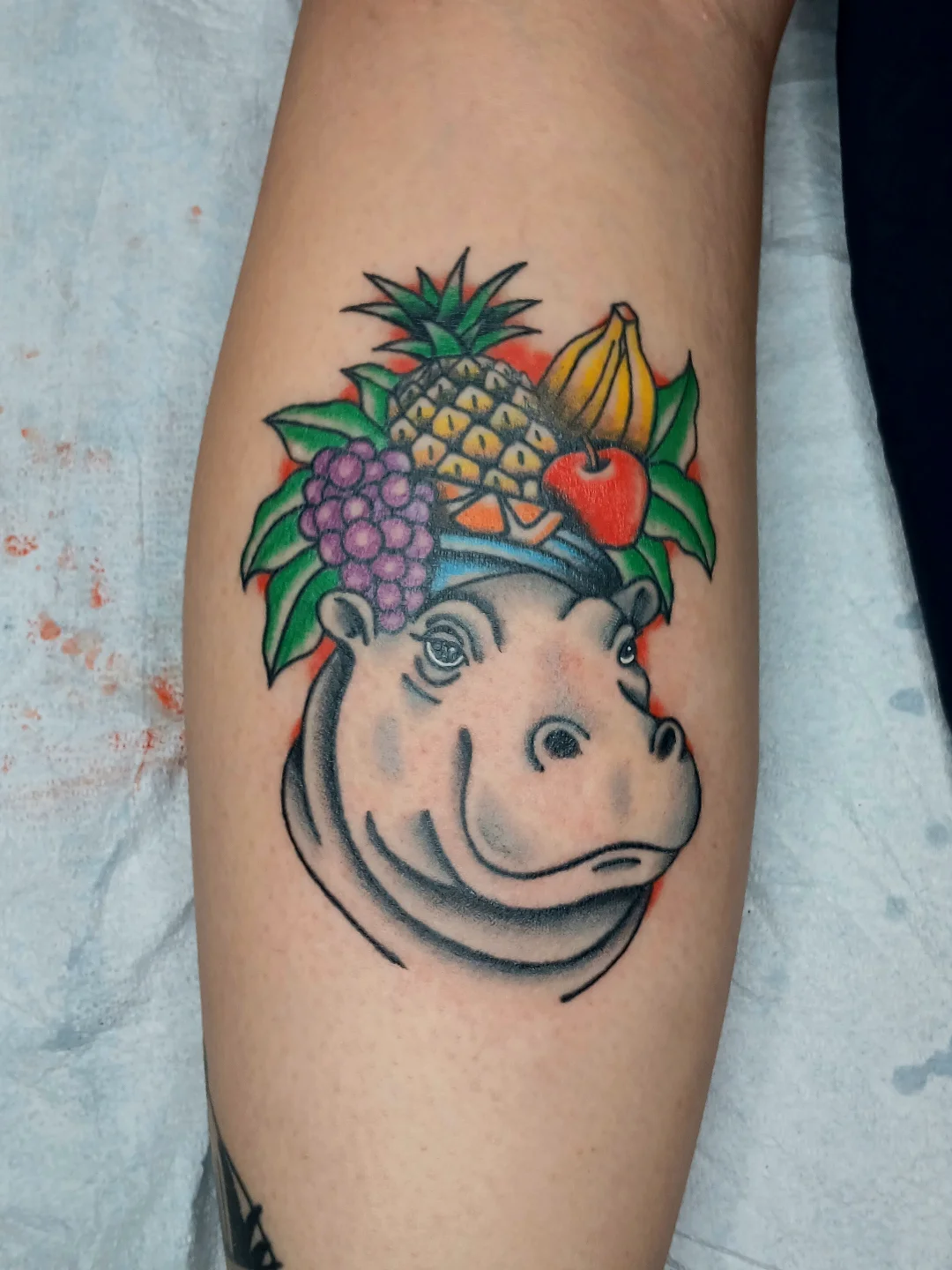 Hippo with fruit crown American traditional tattoo on the forearm by Amber Tattoos