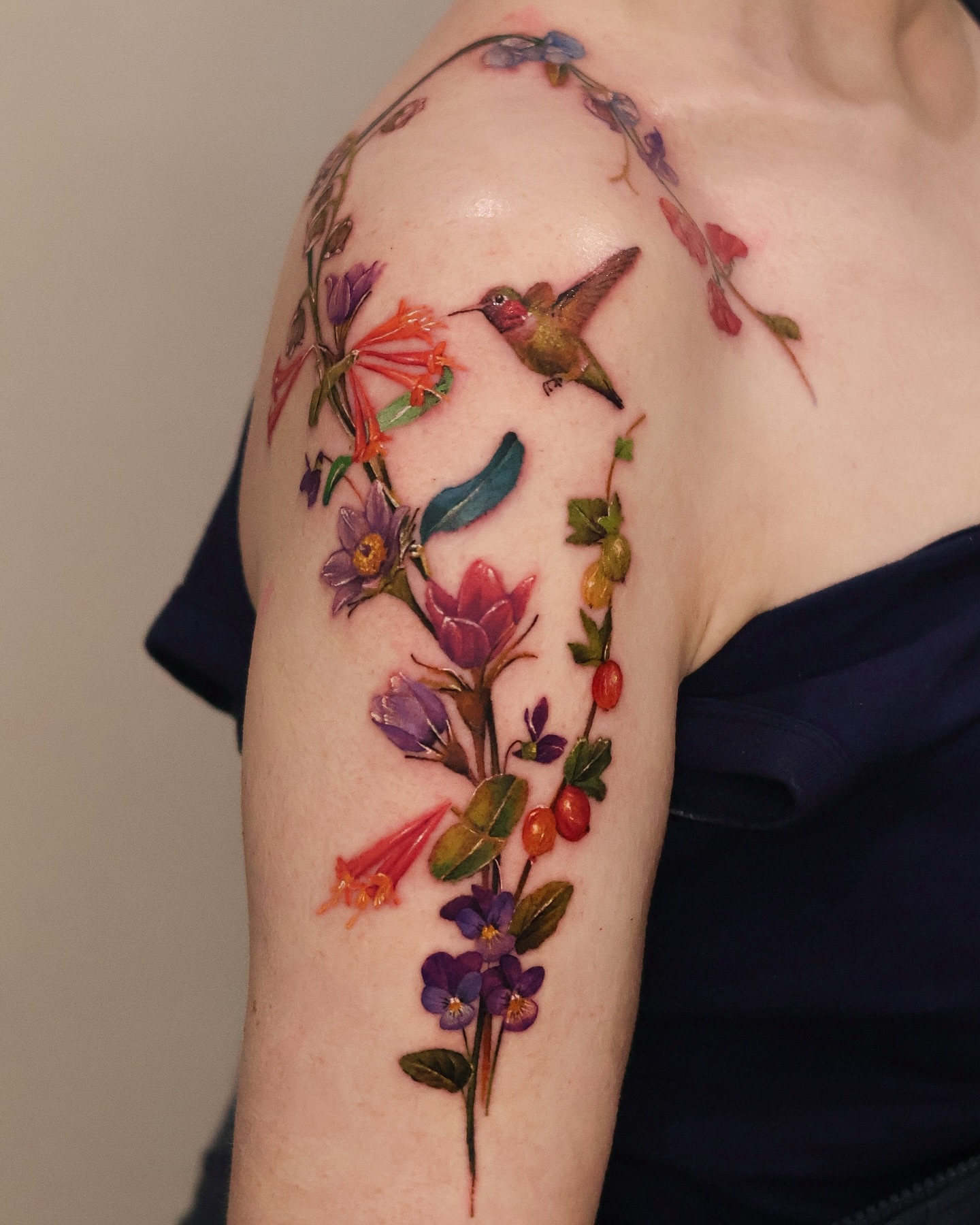 Hummingbird and floral vine realism tattoo on the shoulder by 𝒀𝒖𝒏𝒎𝒊 𝑷𝒂𝒓𝒌