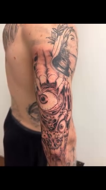 Creepy eyeball and mechanical arm sleeve realism tattoo on the forearm by Chris