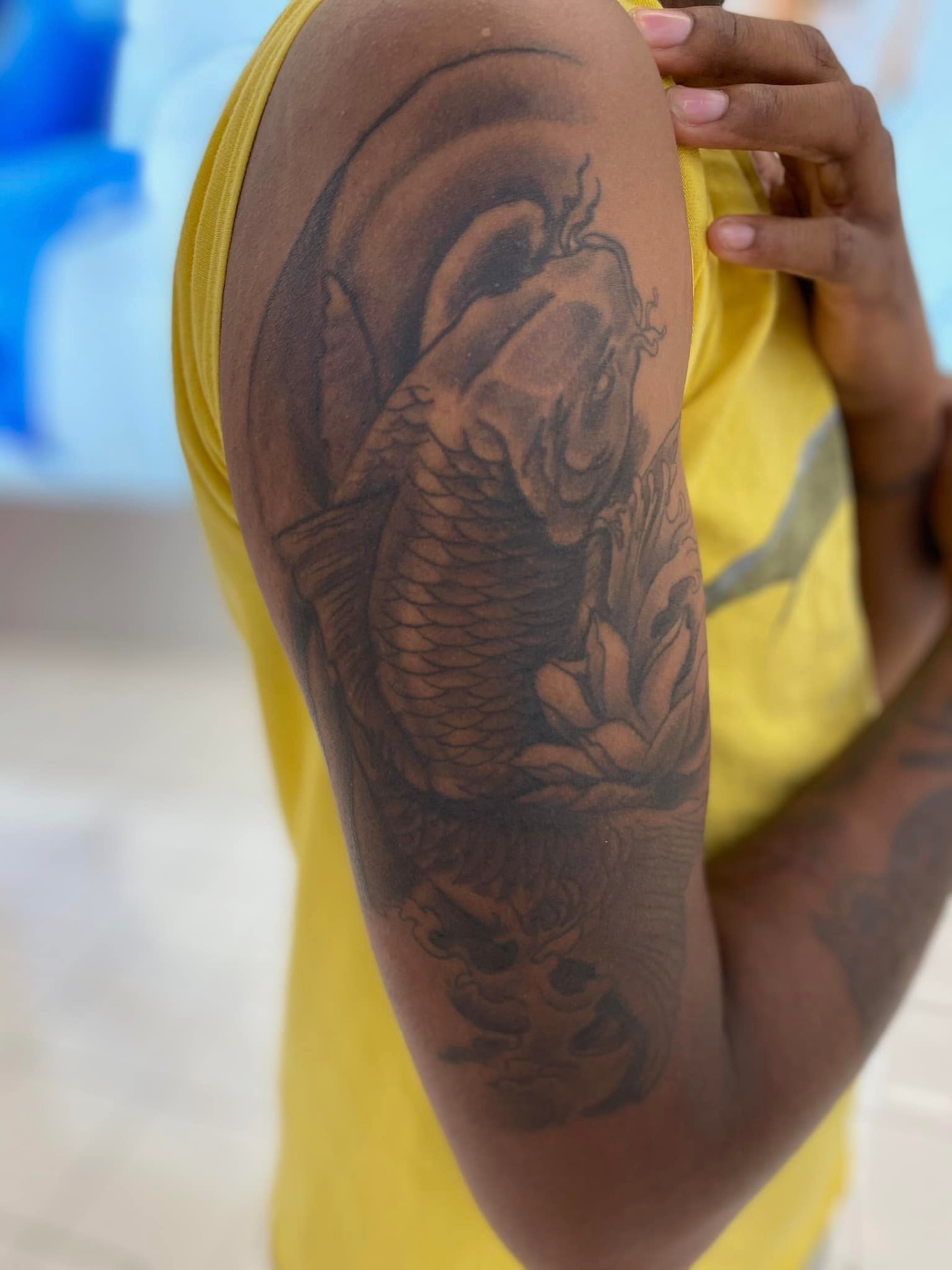 Koi fish black and grey tattoo on the upper arm by @juiceinkythings