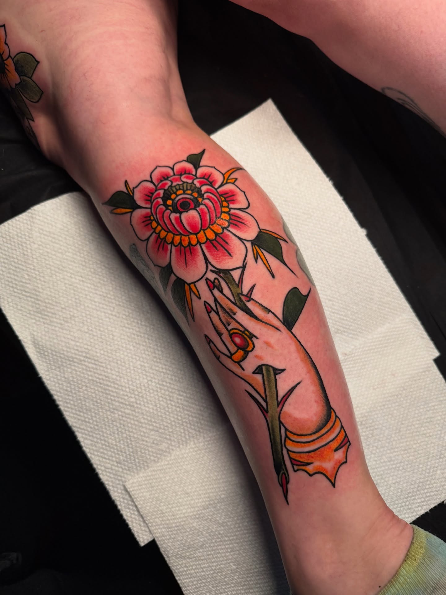 Peony and hand American traditional tattoo on the forearm by E