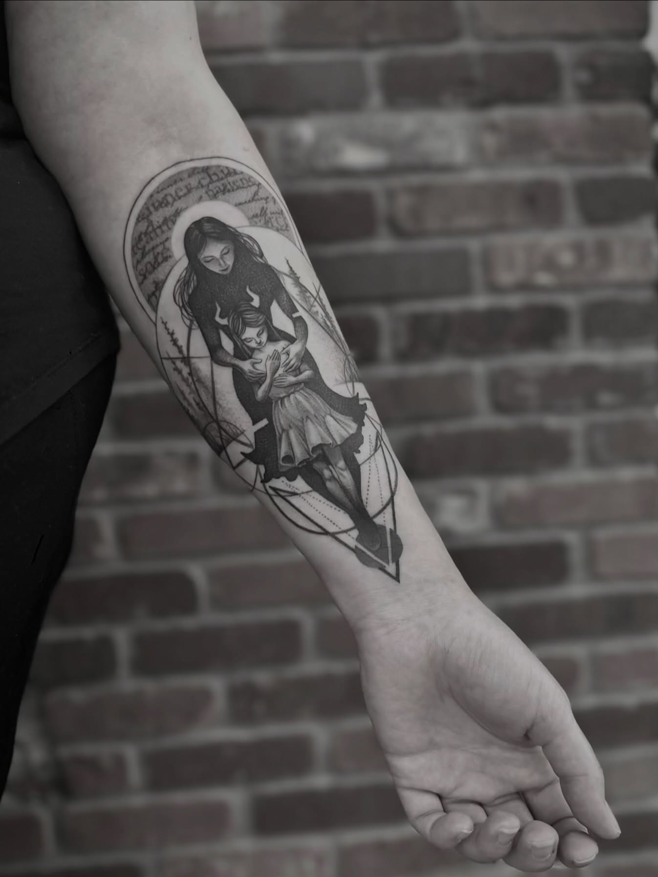 Mother and child geometric tattoo on the forearm by Z.