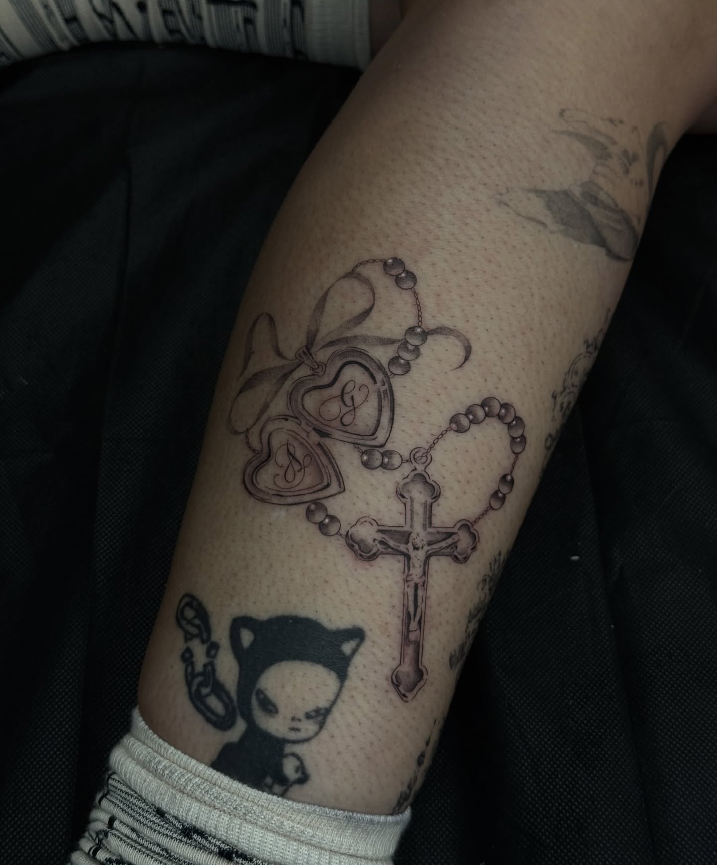 Rosary and hearts black and grey tattoo on the forearm by πΈππππ