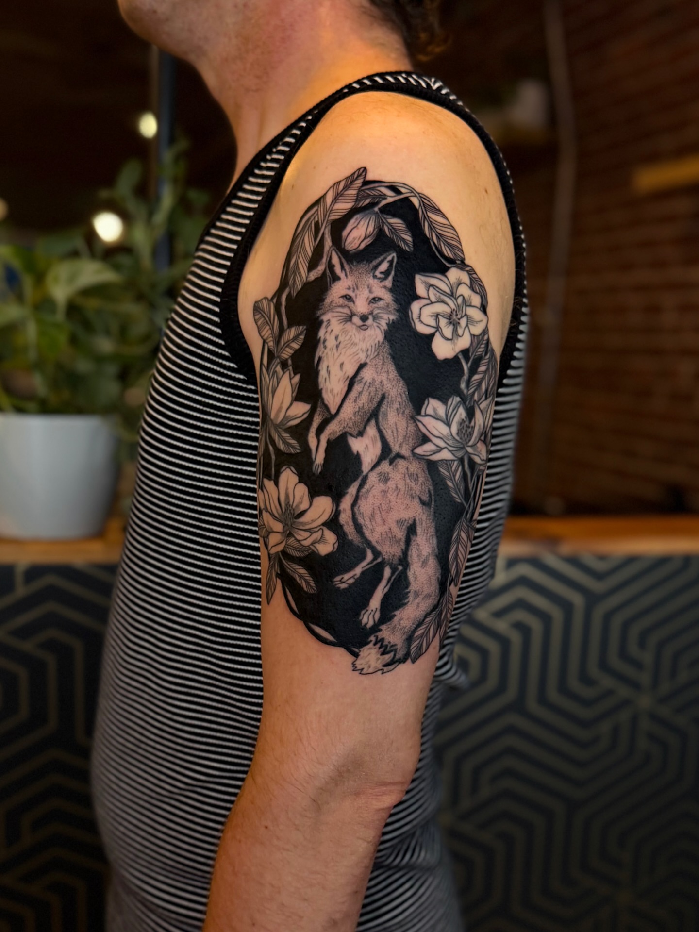Fox and flowers realism tattoo on the upper arm by Alexandra Gray