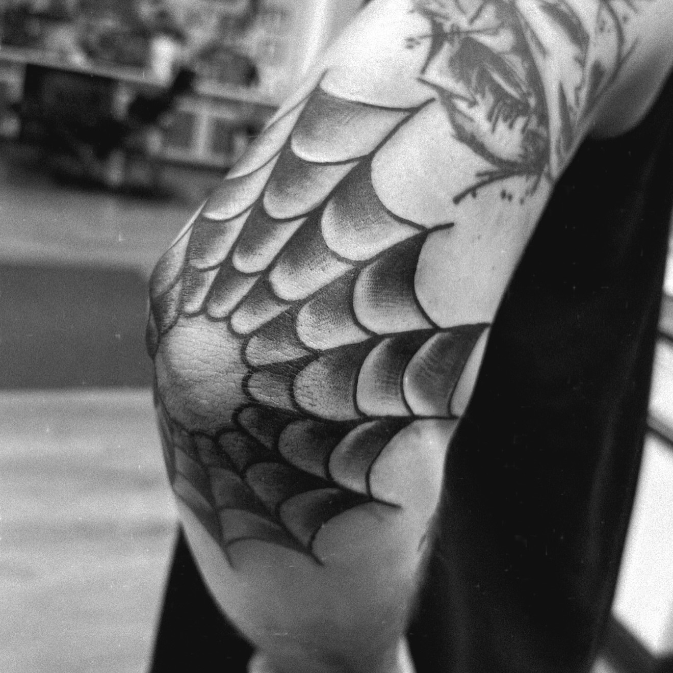 Wing scales black and grey tattoo on the forearm by Justin Hay