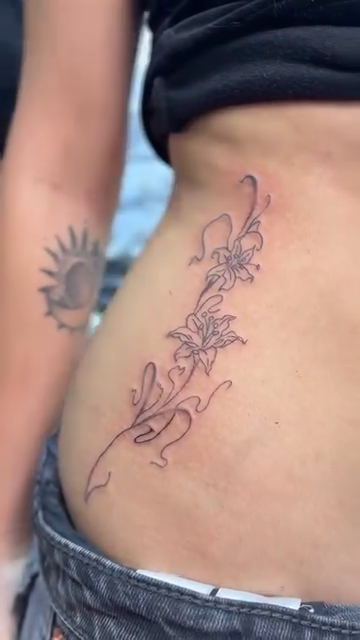 Floral vine tattoo on hip fine line tattoo on the thigh by Jason Topliss