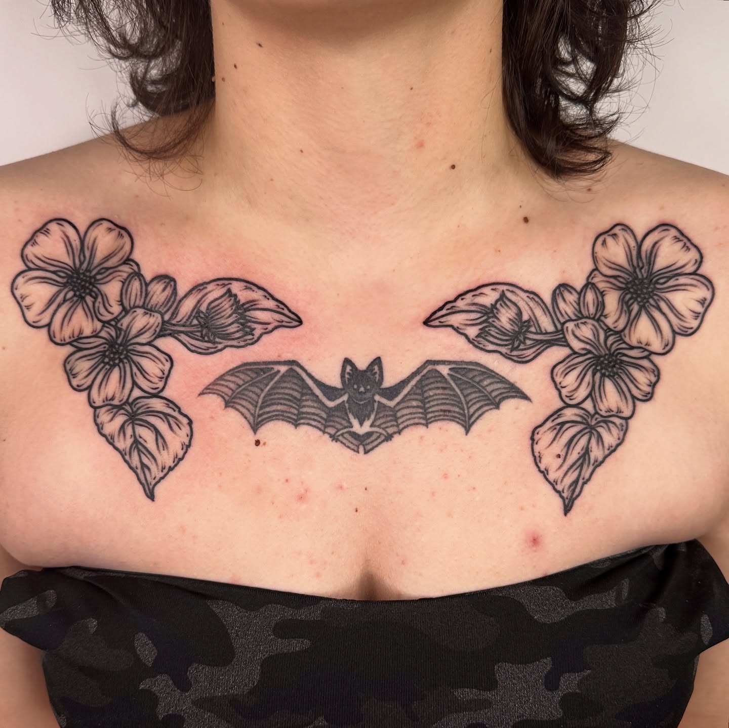 Bat and flowers black and grey tattoo on the chest by rosalie