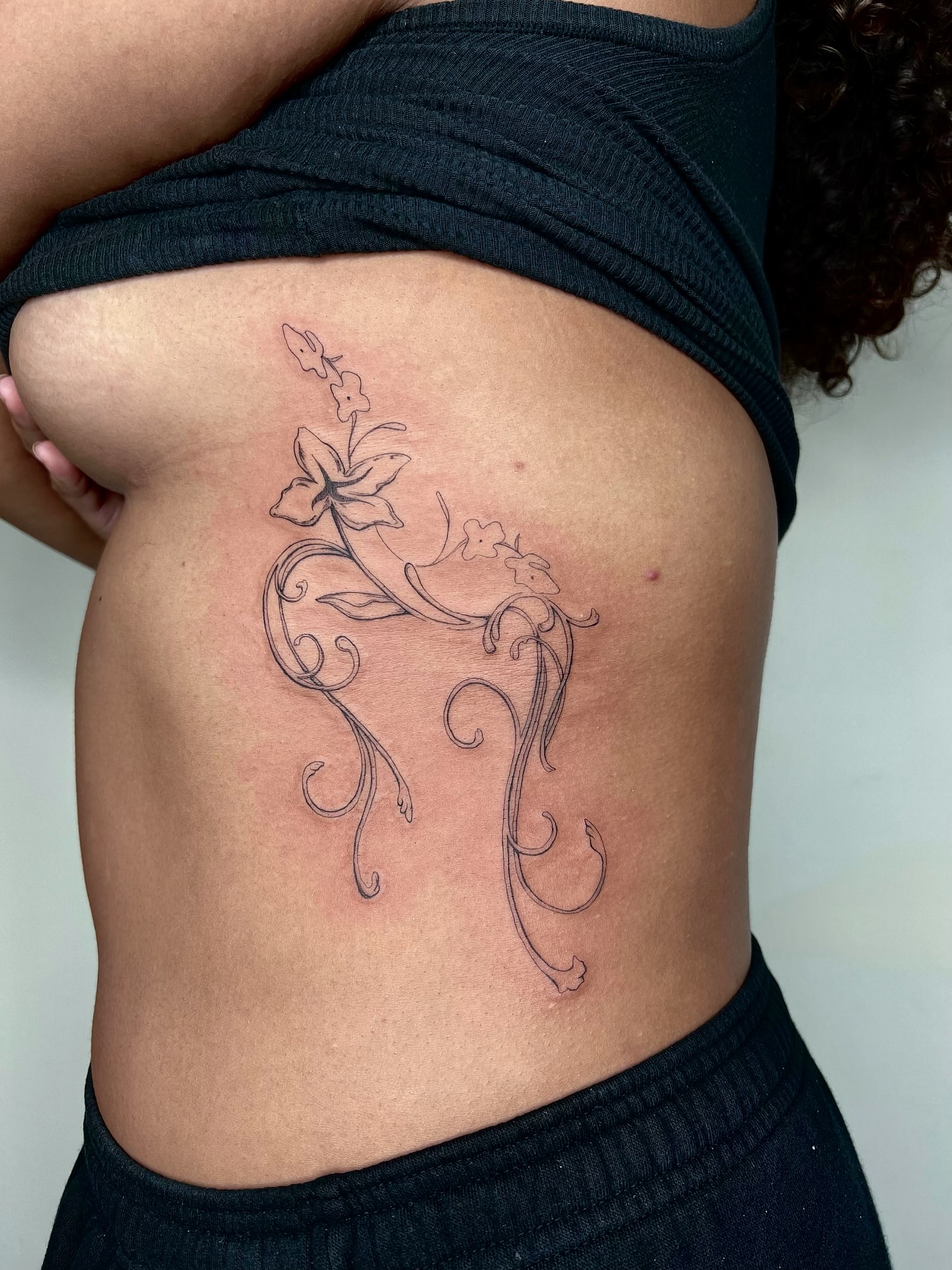Floral vine ornamental tattoo on the ribs by jewel renee