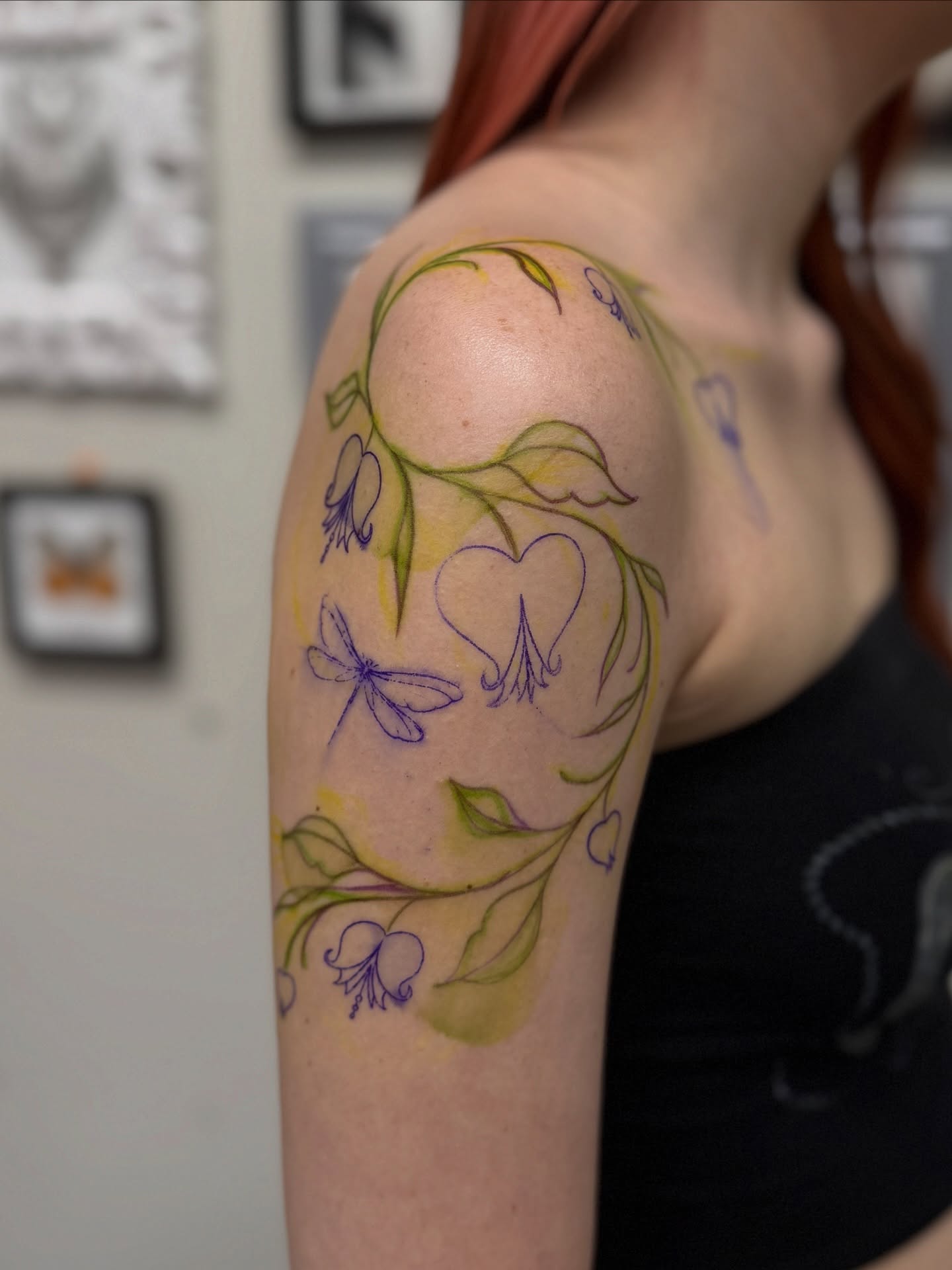 Floral vine watercolor tattoo on the upper arm by liliana lopez