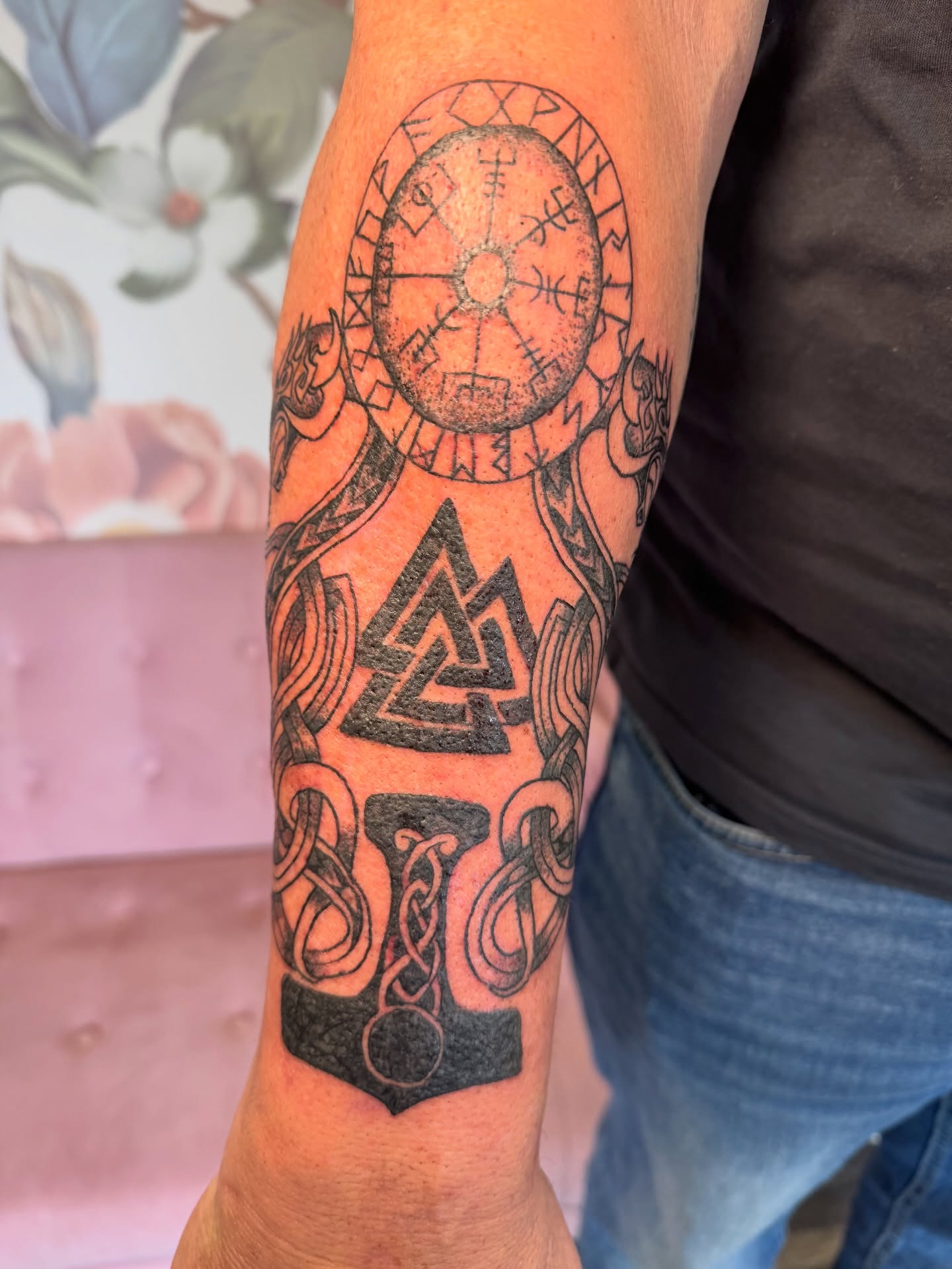 Runic wheel and hammer geometric tattoo on the forearm by Kinzi Brown