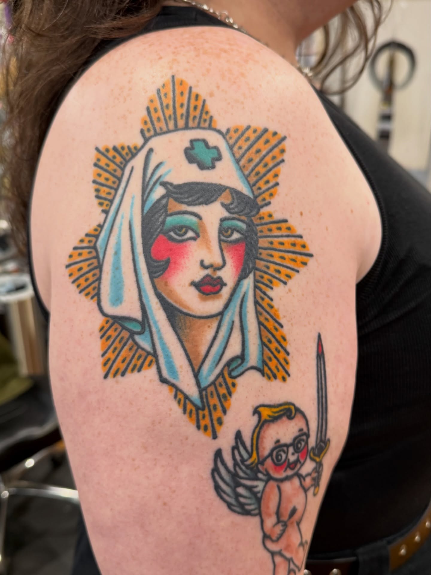 Nurse and cherub American traditional tattoo on the shoulder by Zak Colburn