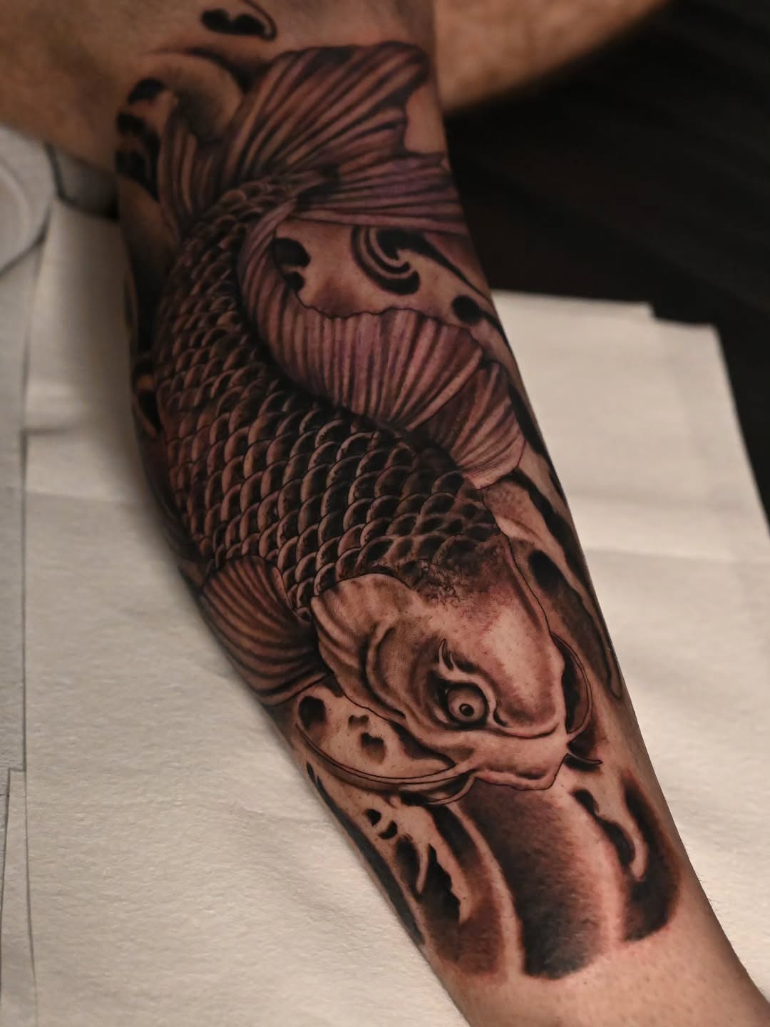 Koi fish black and grey tattoo on the forearm by Michael ORegan