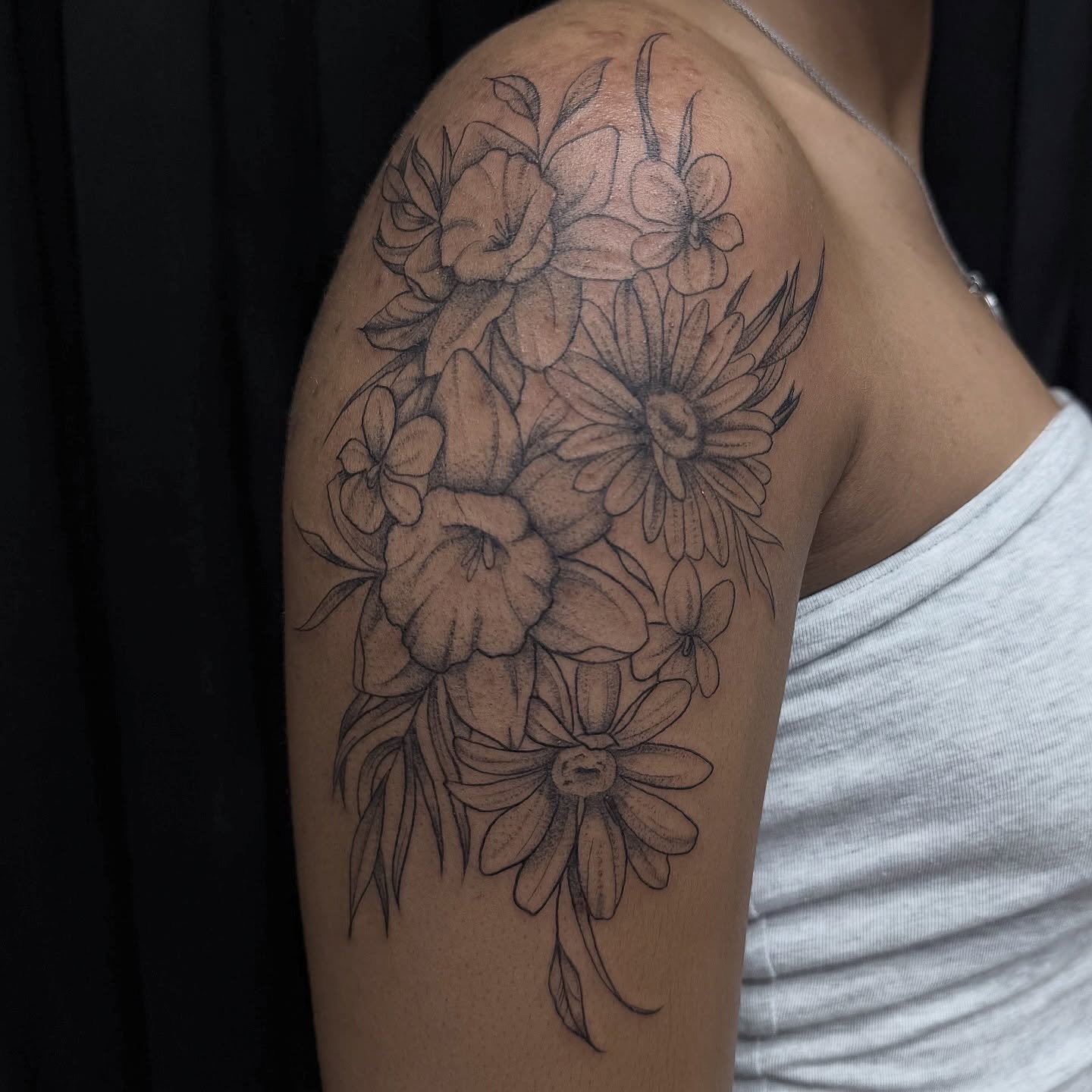 Floral bouquet black and grey tattoo on the shoulder by Sydney Gallucci