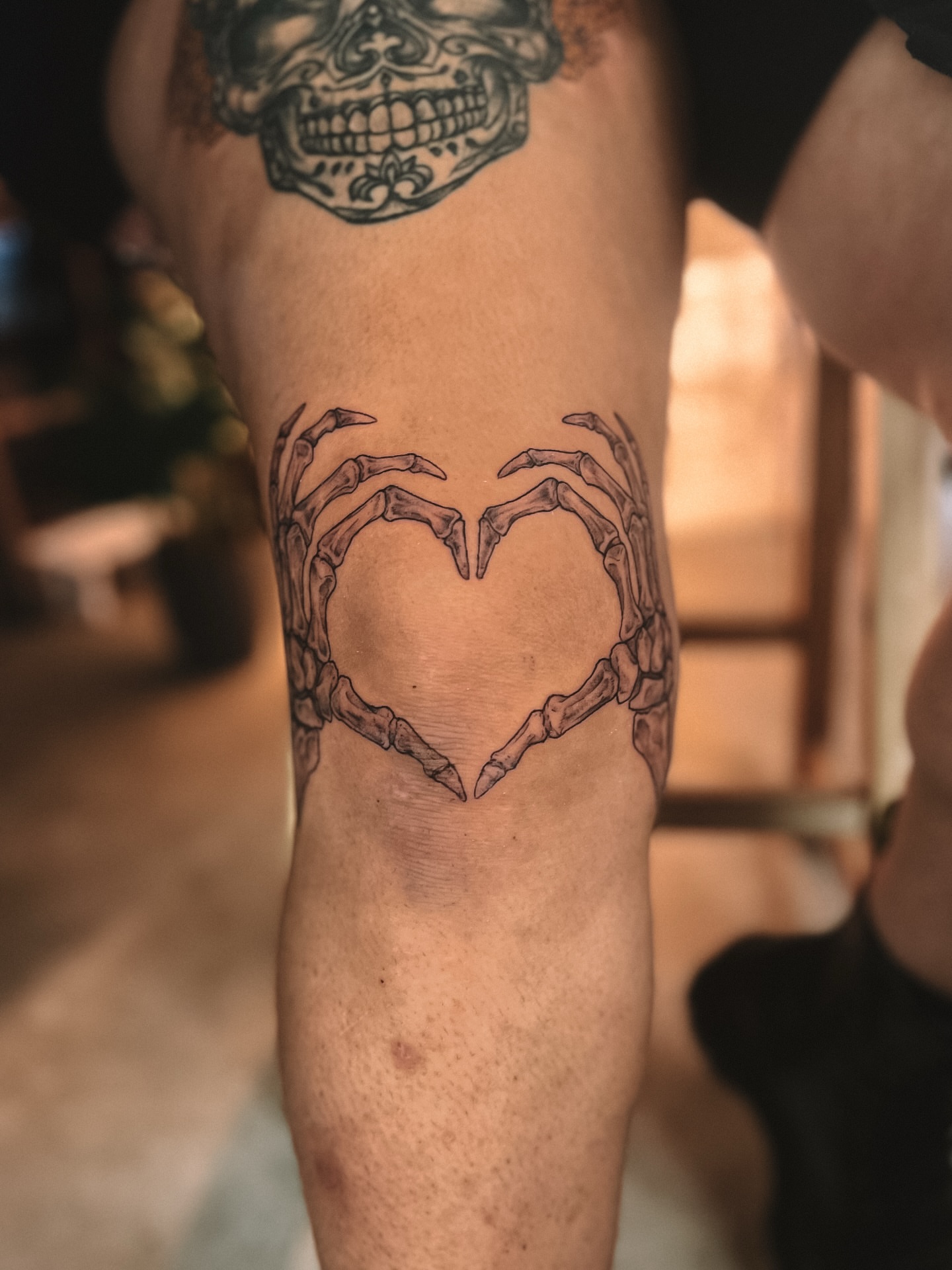 Skeleton hands forming heart black and grey tattoo on the leg by sebs phạm, Los Angeles, California