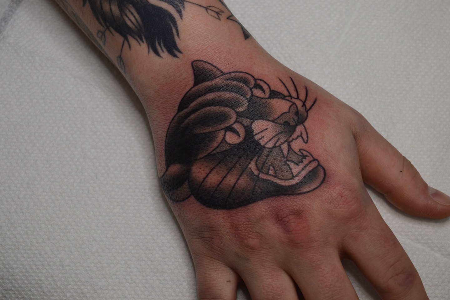 Panther black and grey tattoo on the hand by Vanessa Acosta