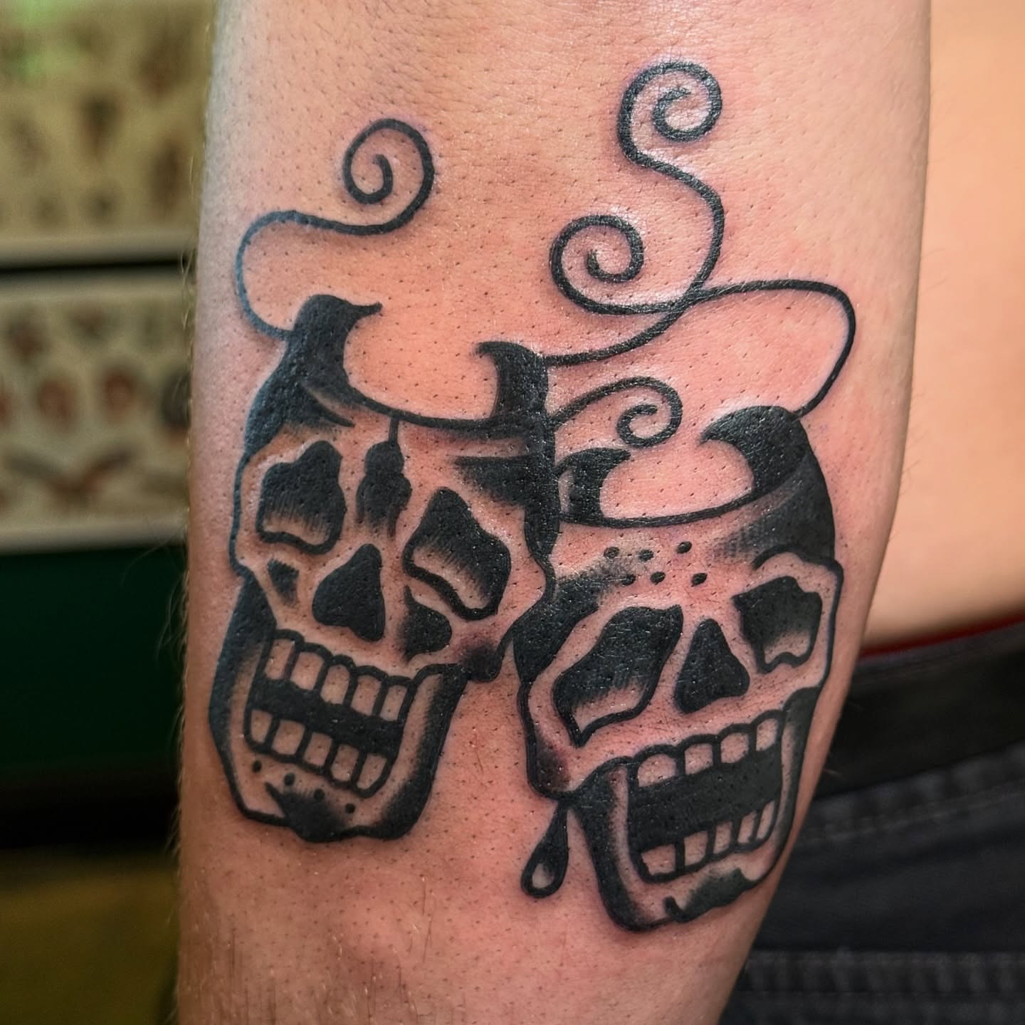 Skulls black and grey tattoo on the forearm by Erik Sheppard
