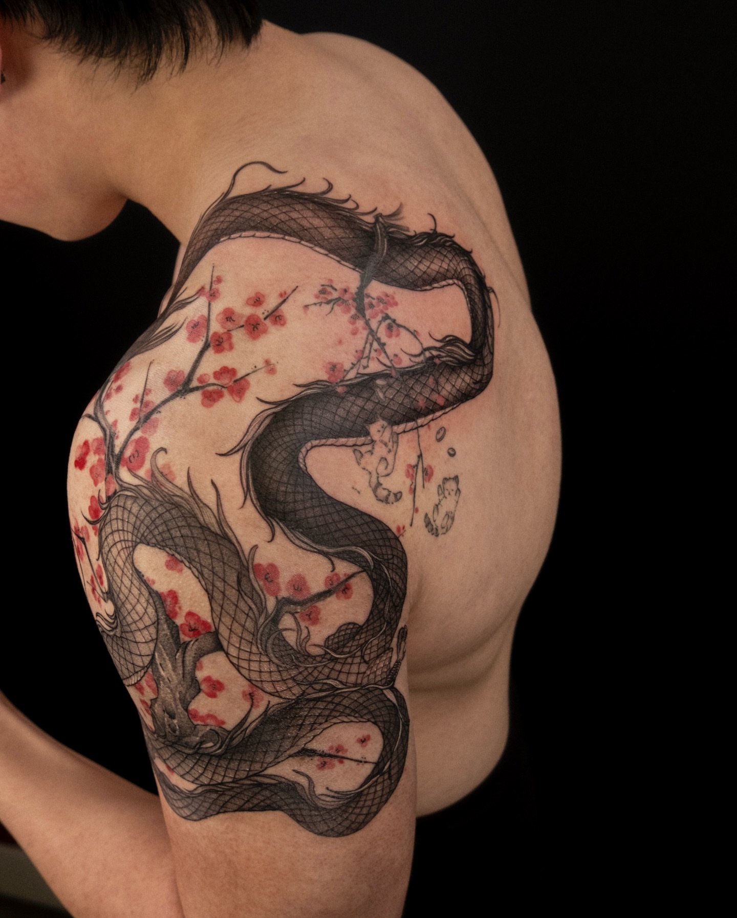 Snake and blossoms realism tattoo on the shoulder by Wong Lee