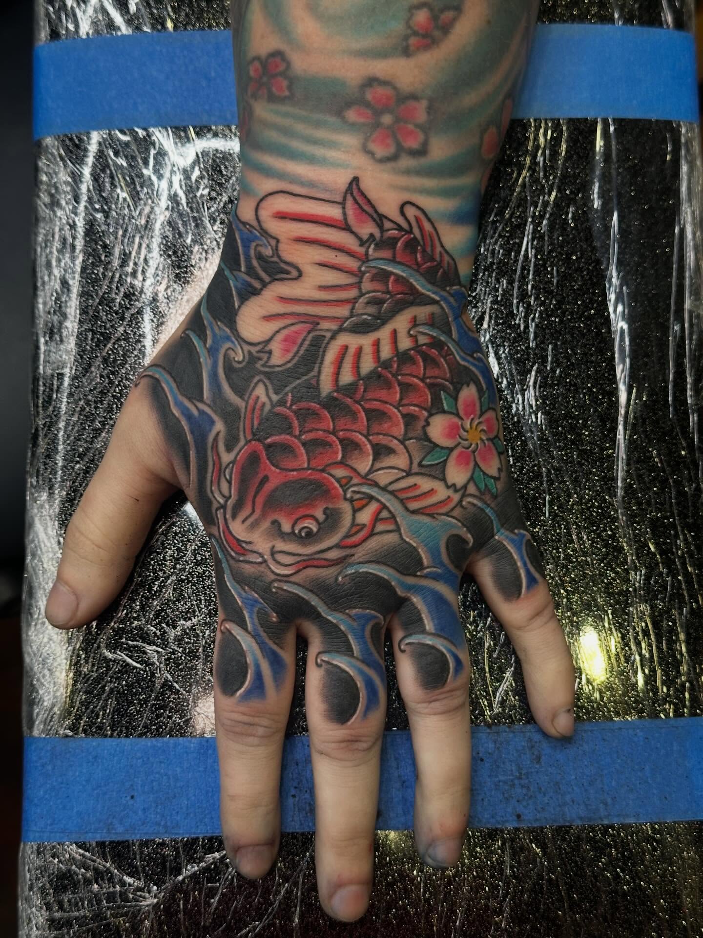 Koi fish and waves Japanese tattoo on the hand by Wesley Lam