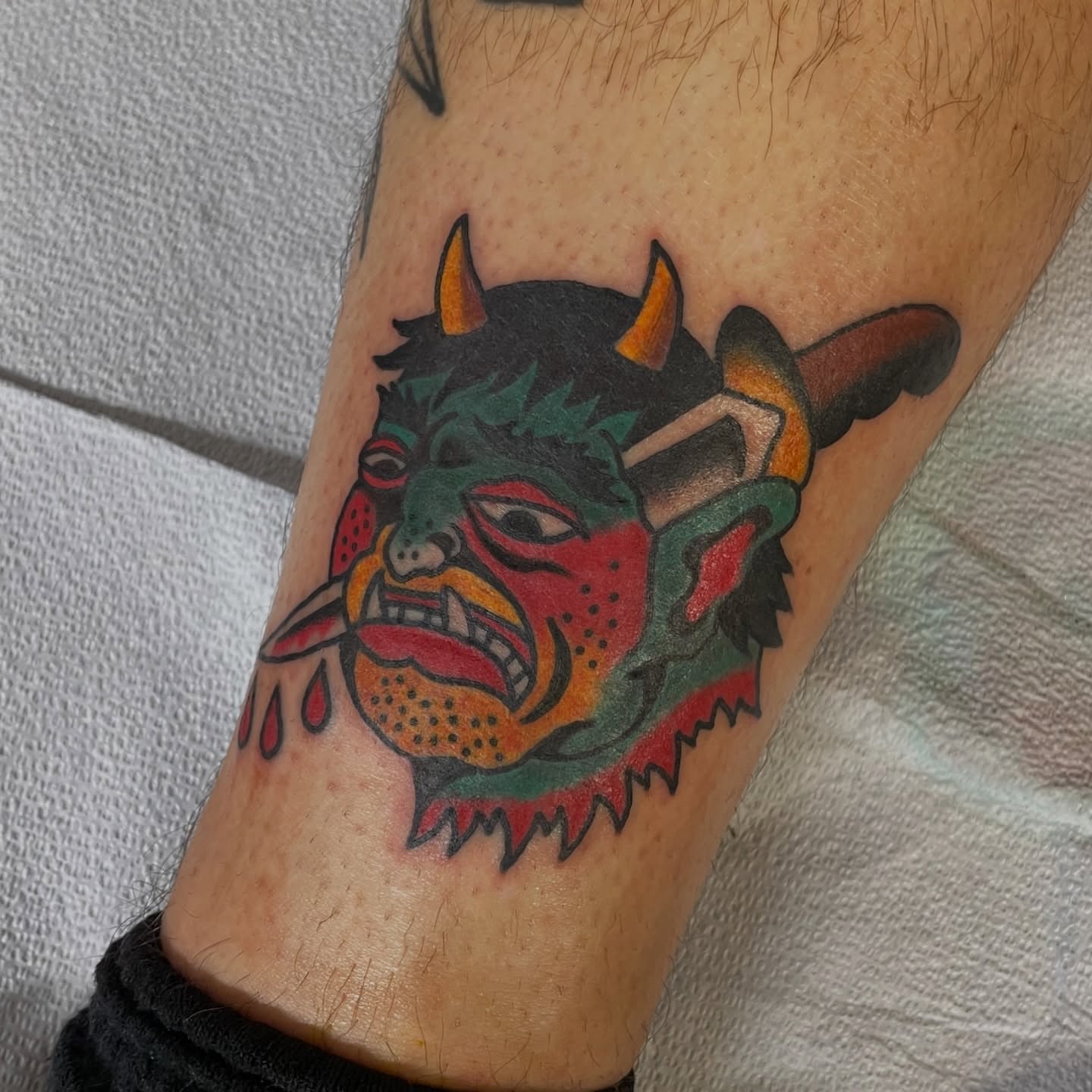 Demon mask American traditional tattoo on the forearm by Greg De Hoot, Youngsville, North Carolina