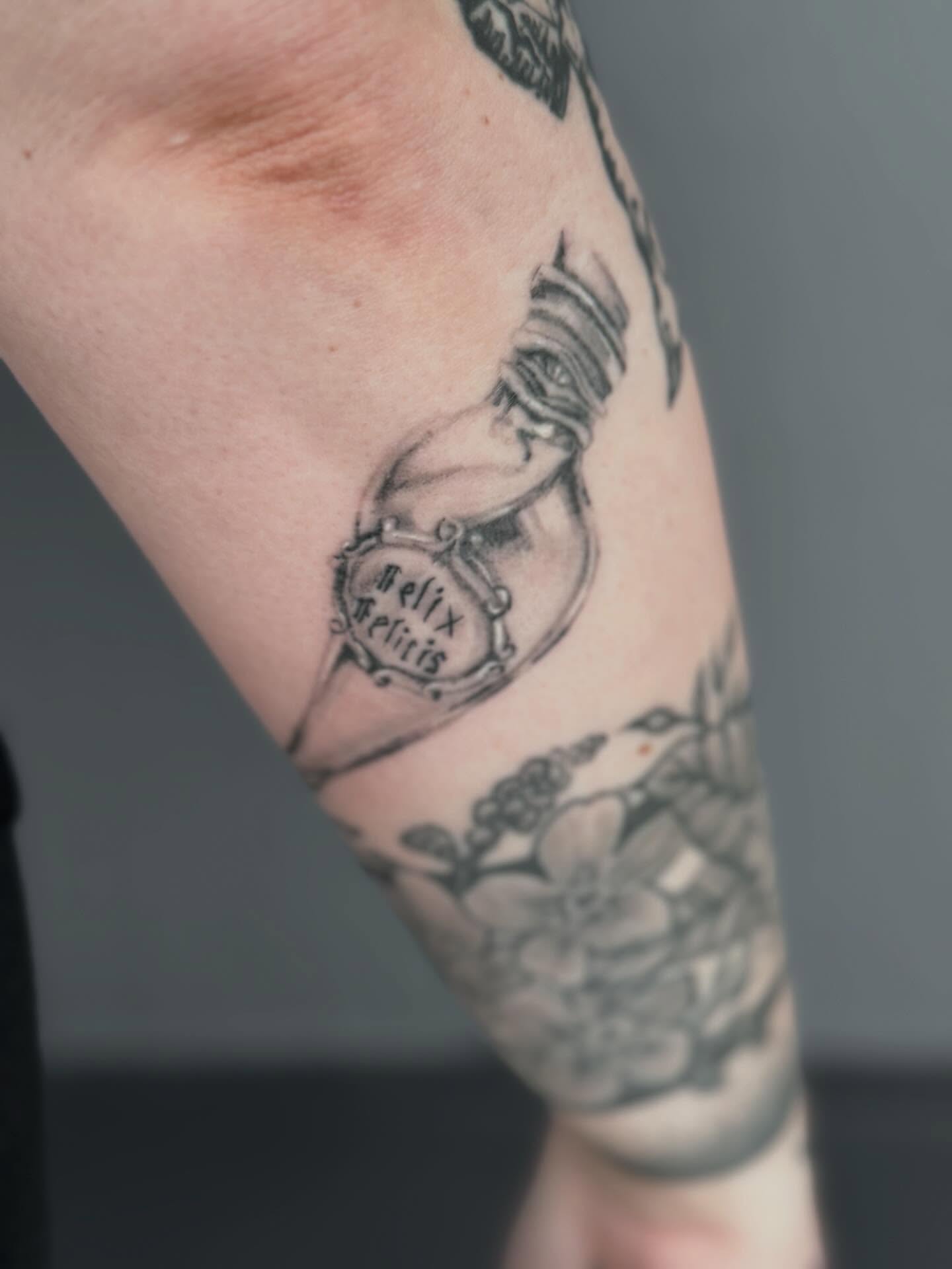 Hourglass black and grey tattoo on the forearm by Gisette Gomez