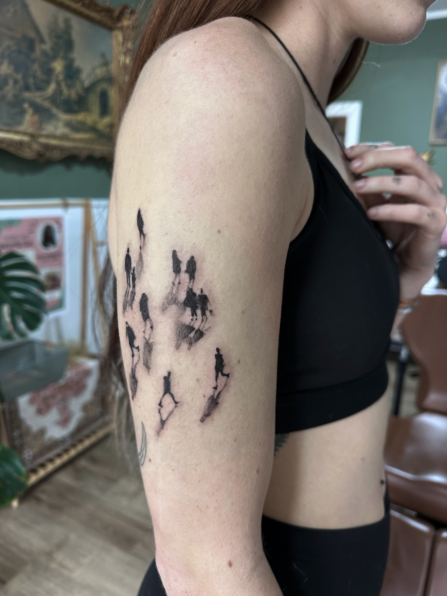 Silhouette of people walking dotwork tattoo on the upper arm by Allexis