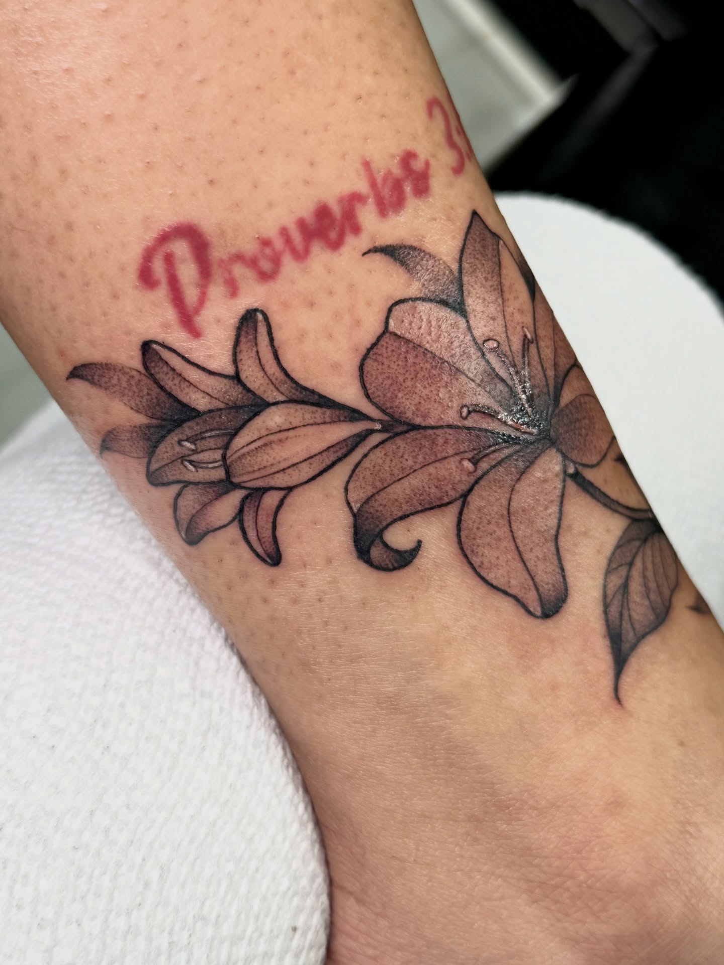 Lilies black and grey tattoo on the forearm by Tattoo Artist