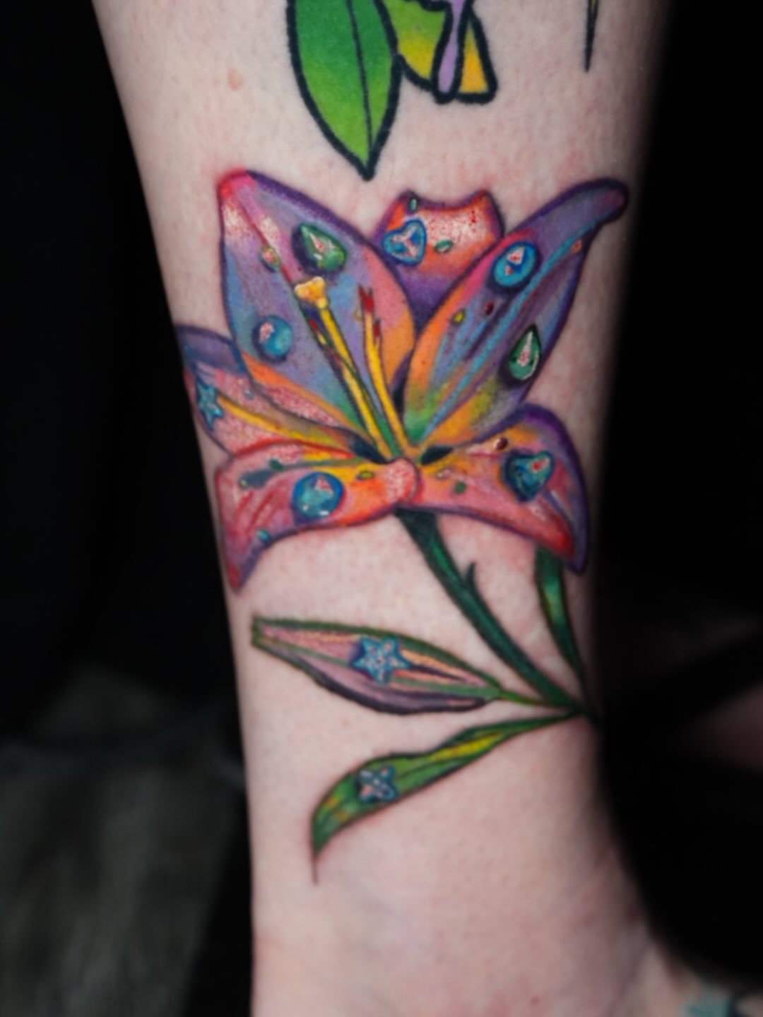 Lily watercolor tattoo on the forearm by Rayvin Patton